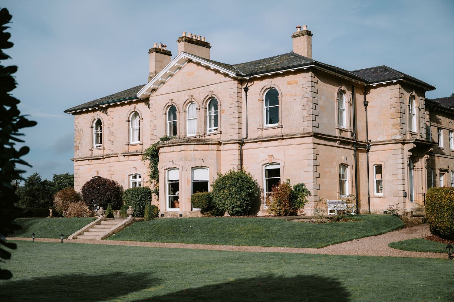 Stately pink stone mansion with classic architecture serves as an elegant wedding venue.