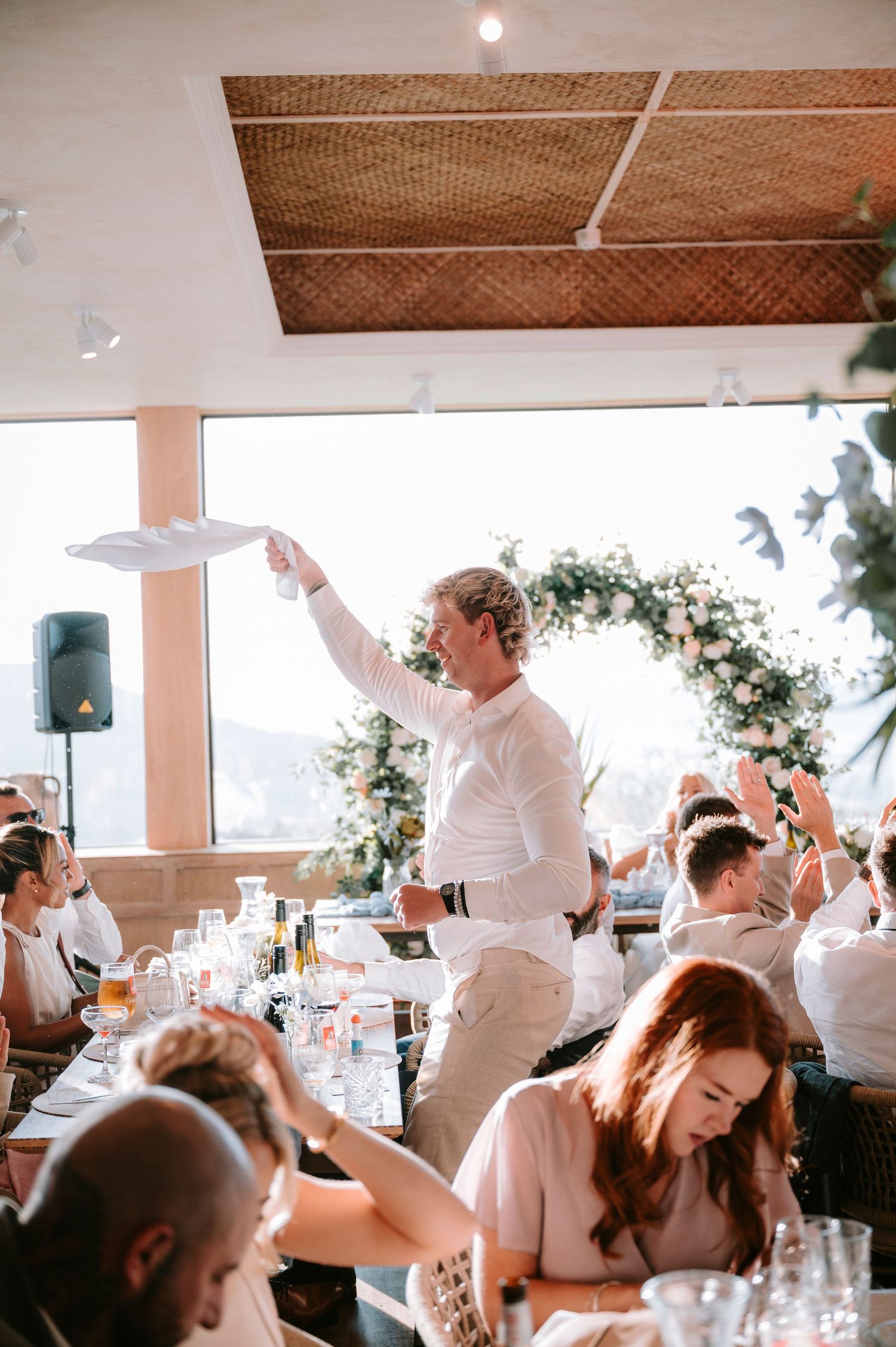Wedding reception party with guests dancing and celebrating in a bright indoor venue.