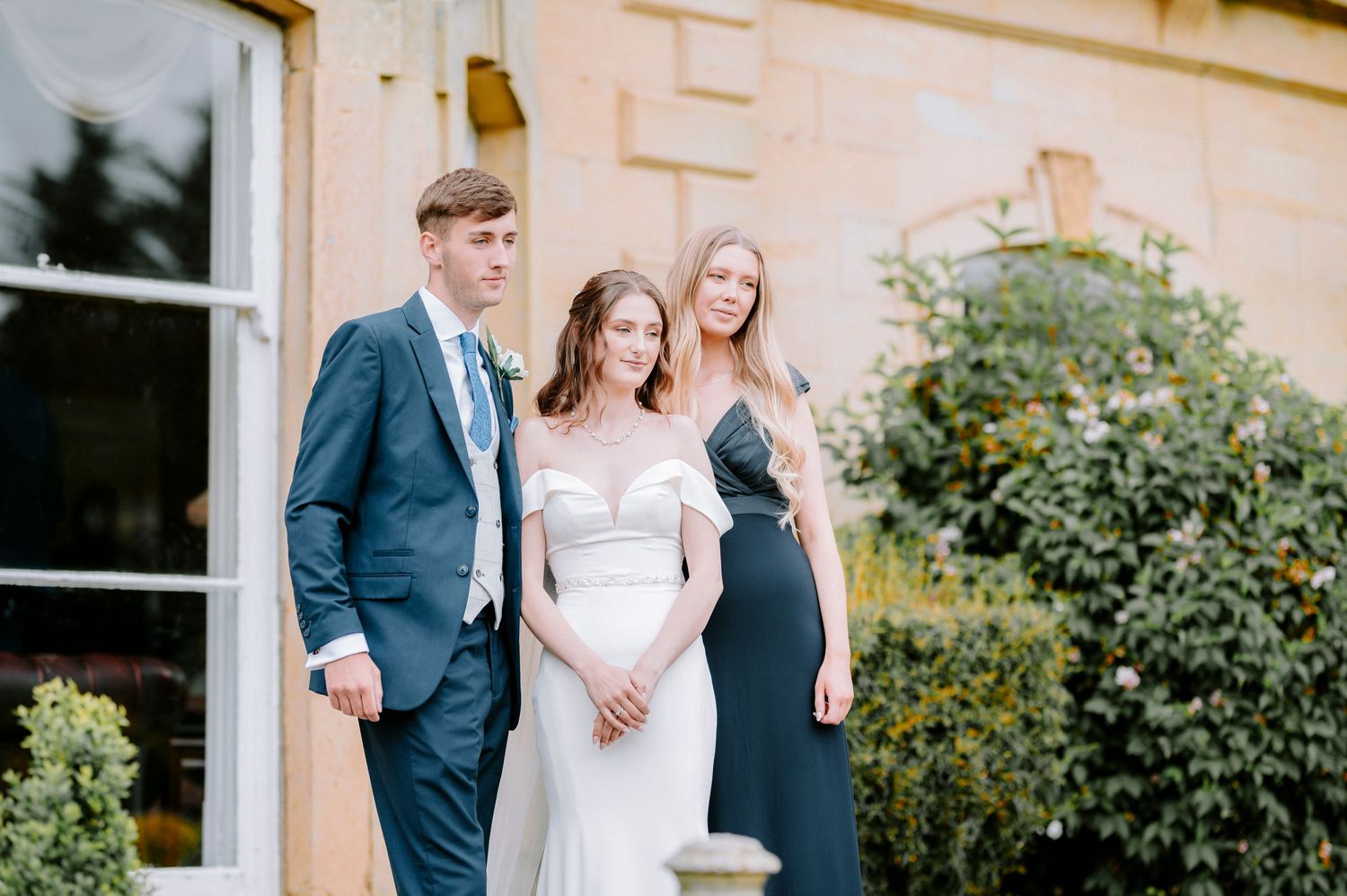 Wedding party gathered outside venue for formal photographs.