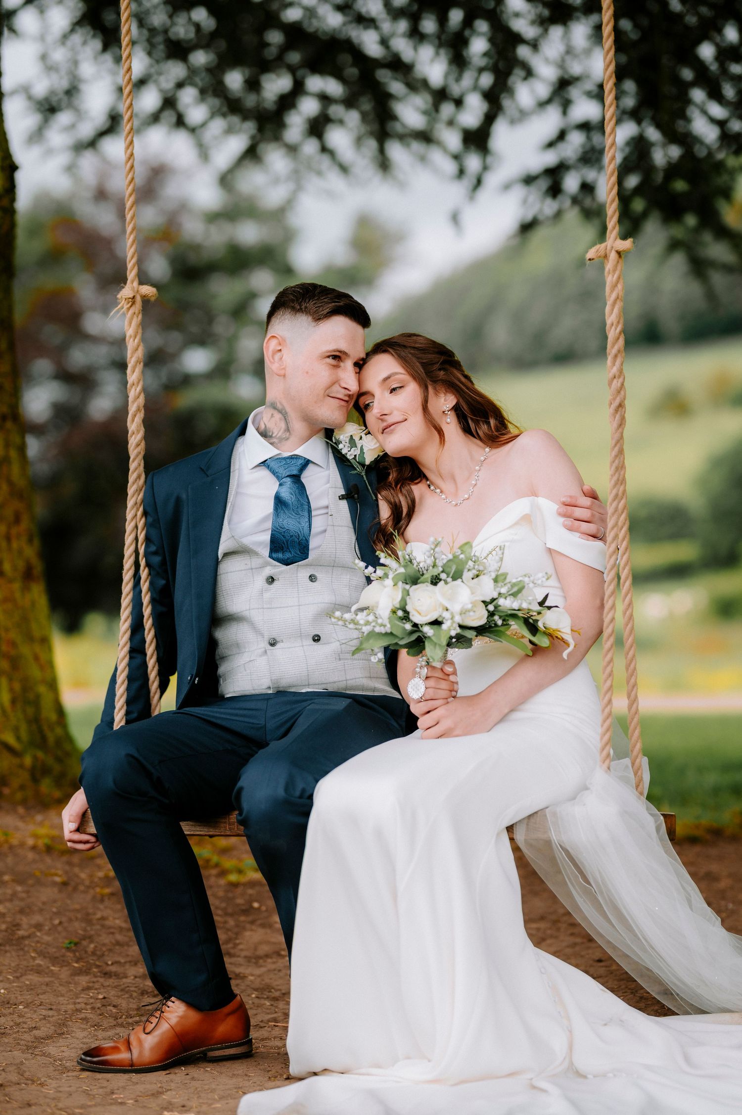 Romantic wedding photos of a couple sharing intimate moments while sitting together on a rope swing.