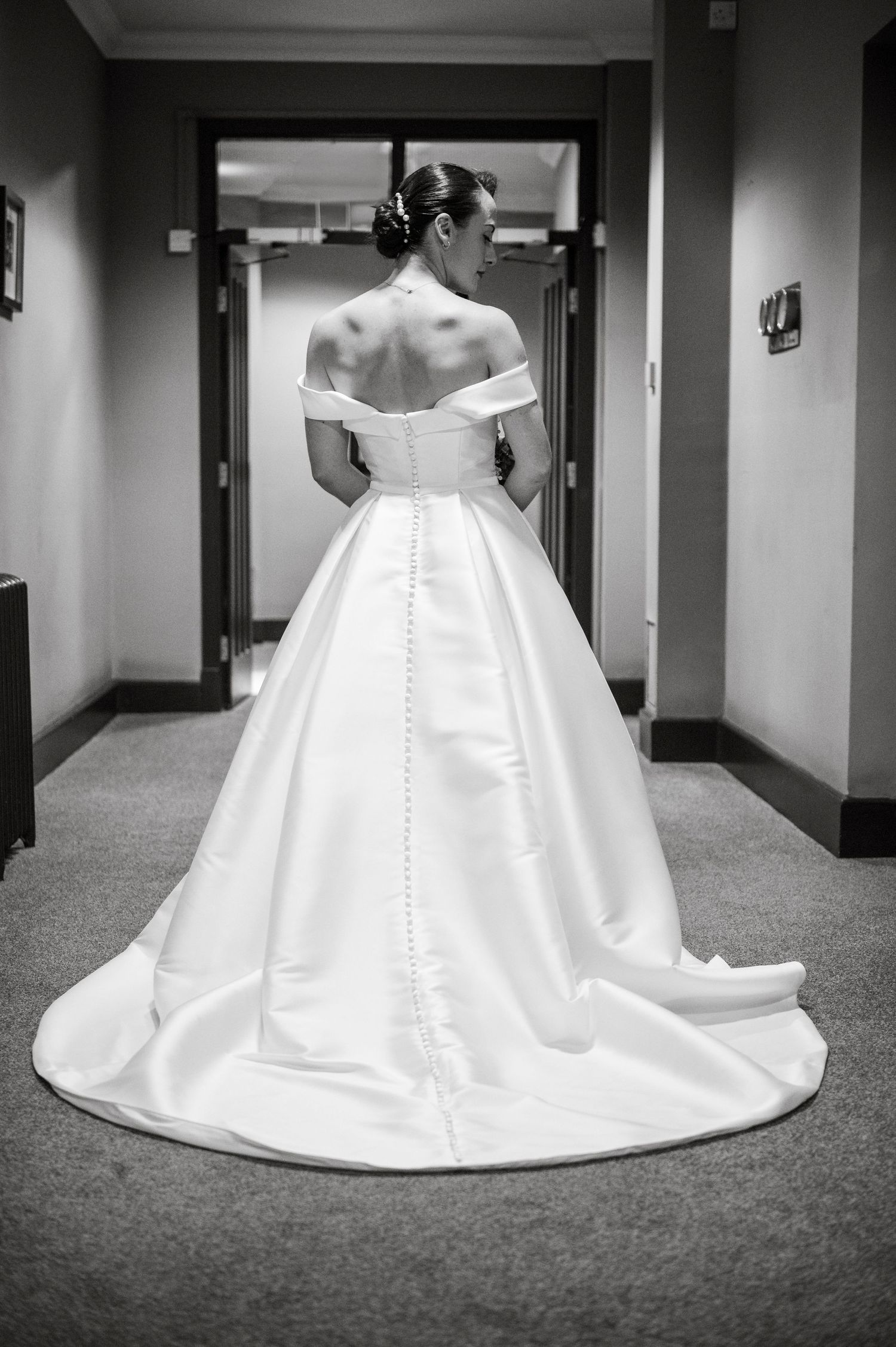 Black and white photos showing the dramatic train of an elegant wedding gown in a hallway.