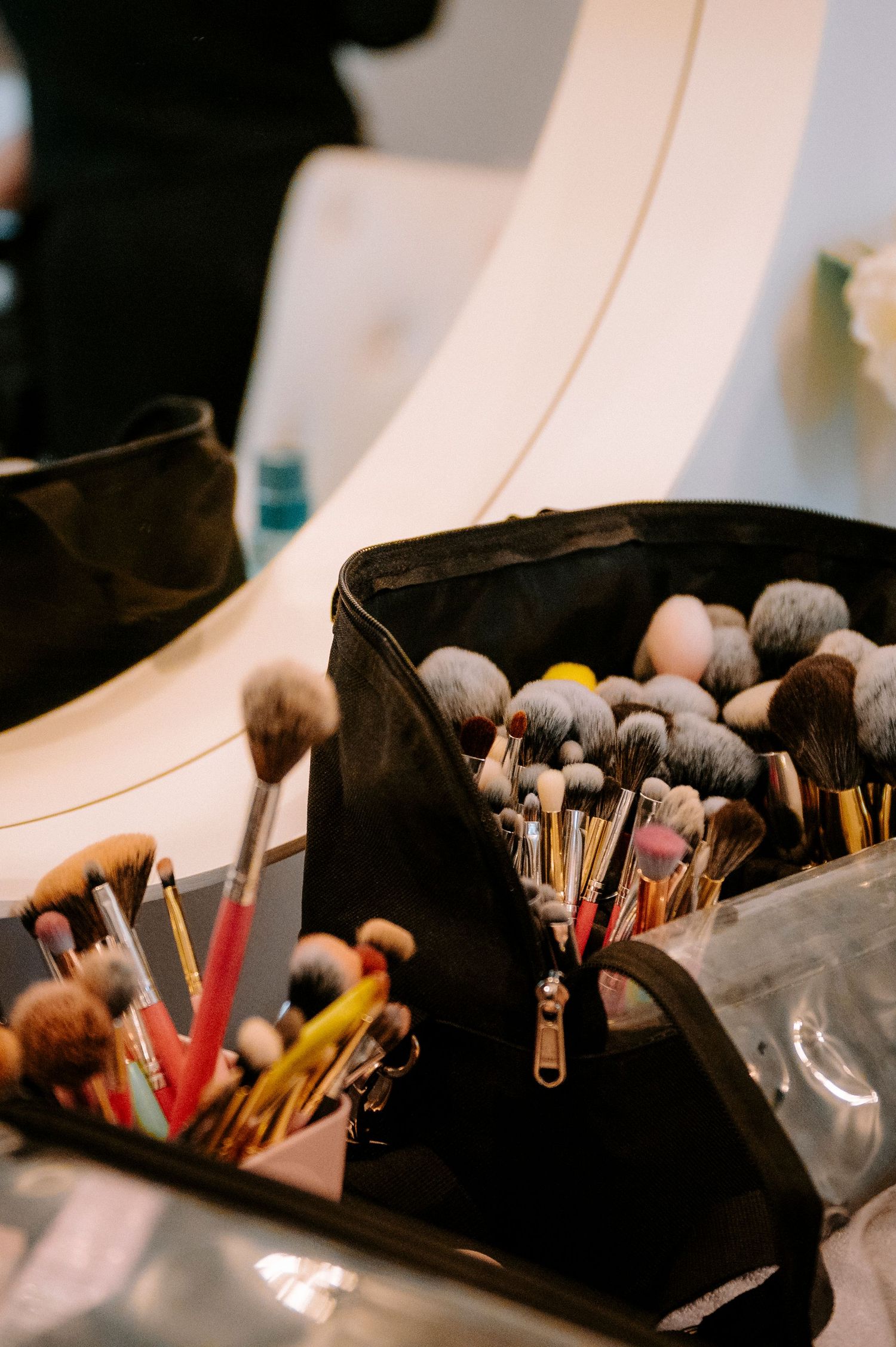Collection of professional makeup brushes arranged on a dark surface.