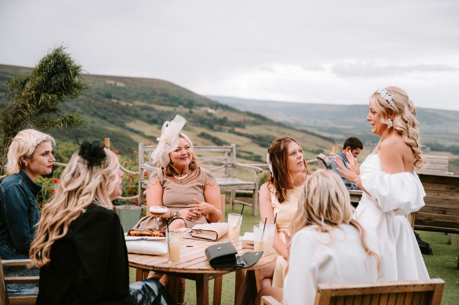 Wedding celebration on an outdoor patio overlooking scenic mountain views during golden hour.