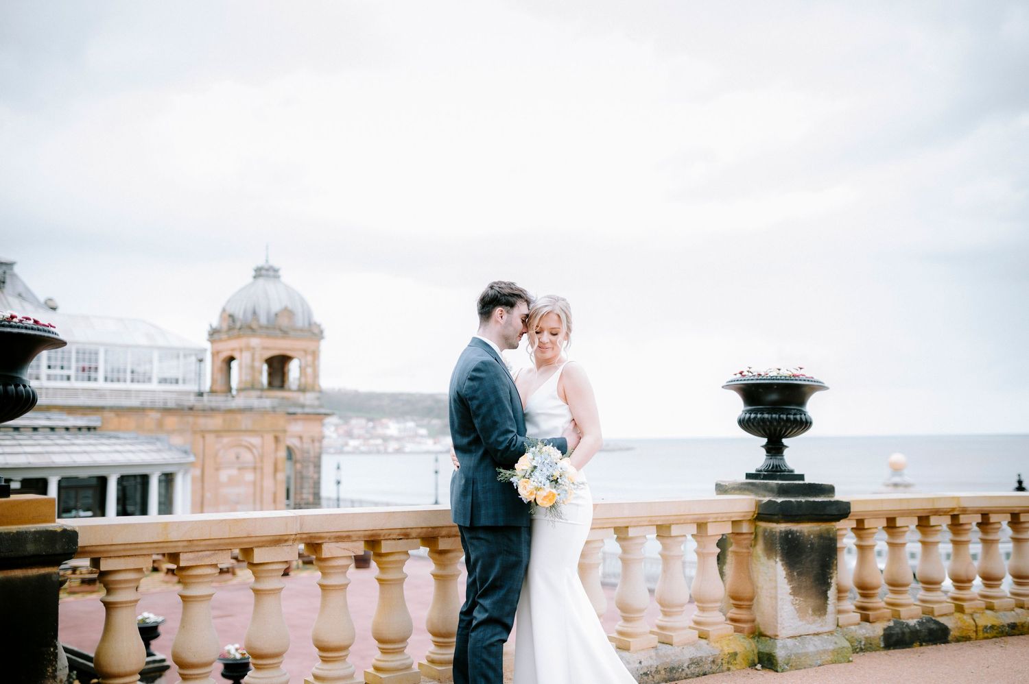 Romantic balcony setting with ornate stone railings overlooking a scenic view.