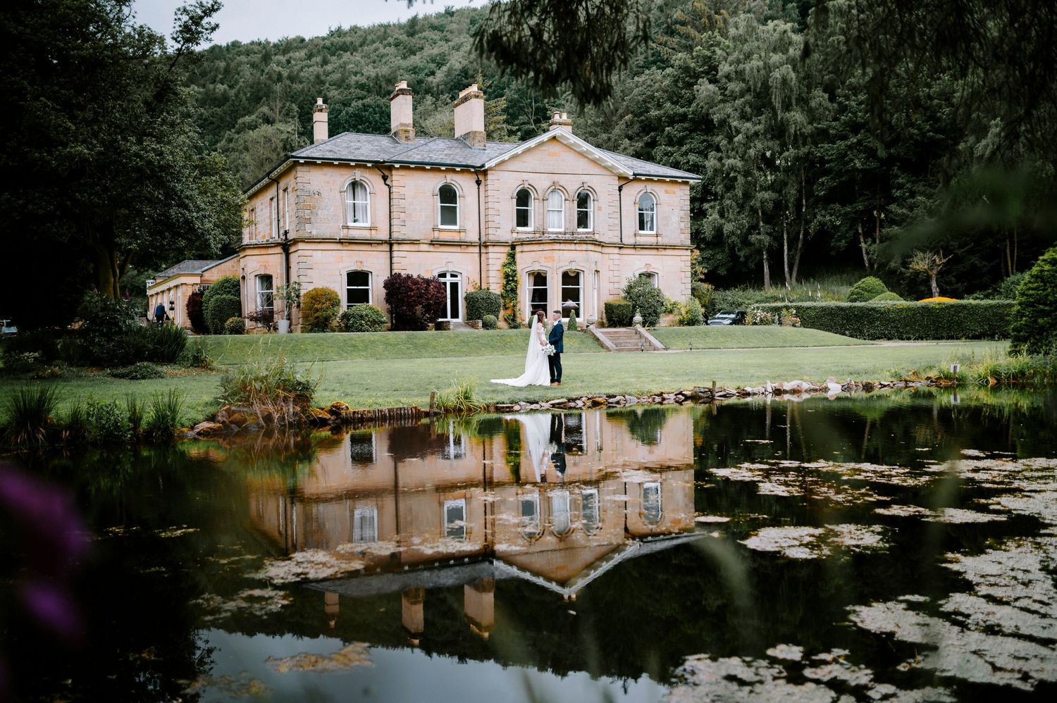 Panoramic view of a historic mansion wedding venue with beautiful water features and grounds.