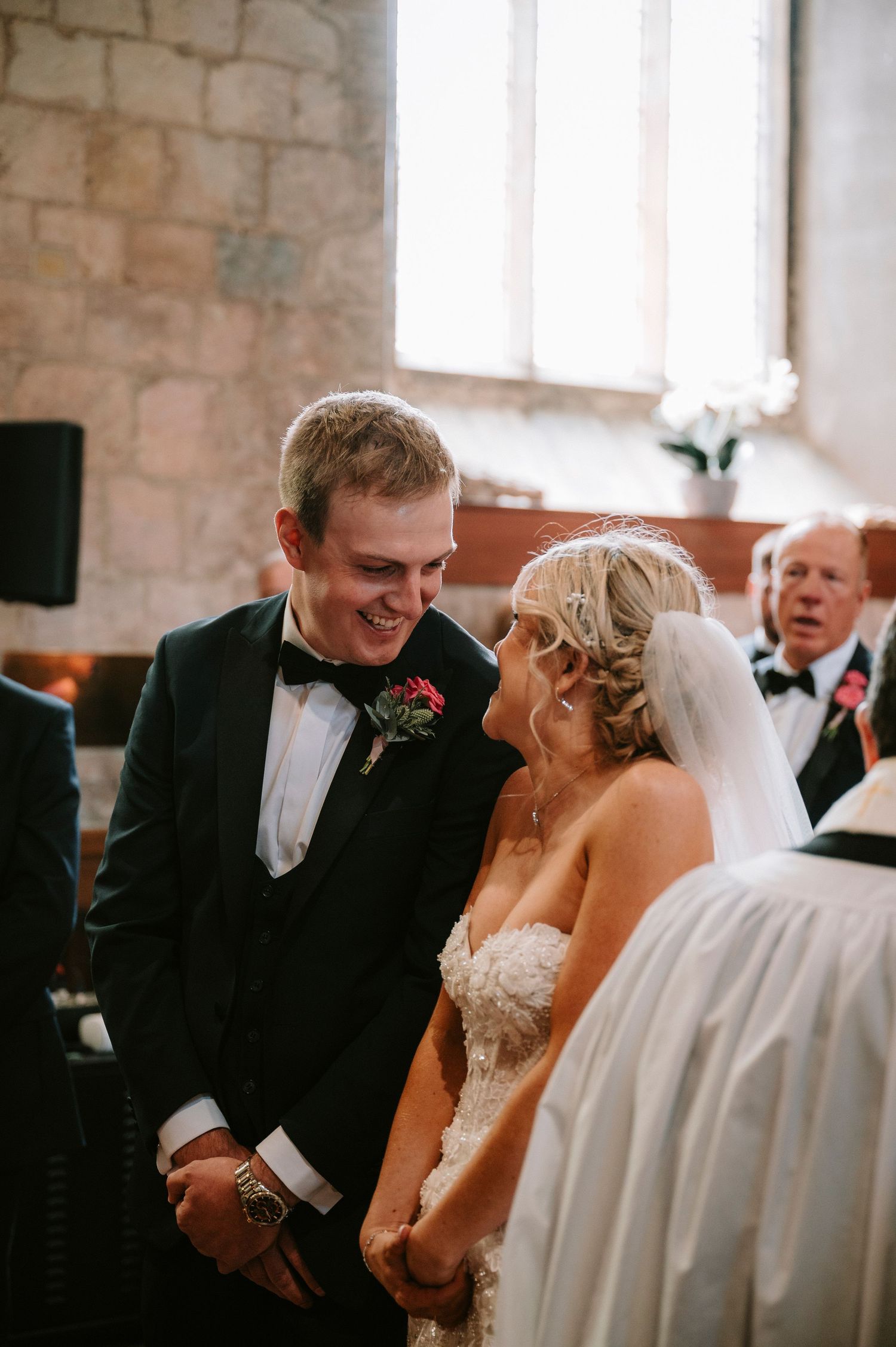 Joyful moment captured during wedding ceremony inside historic stone church.