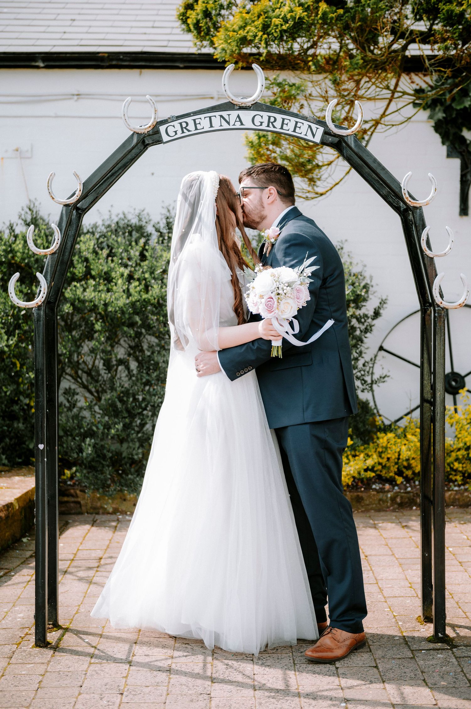 Romantic wedding ceremony moments captured under the iconic Gretna Green archway.