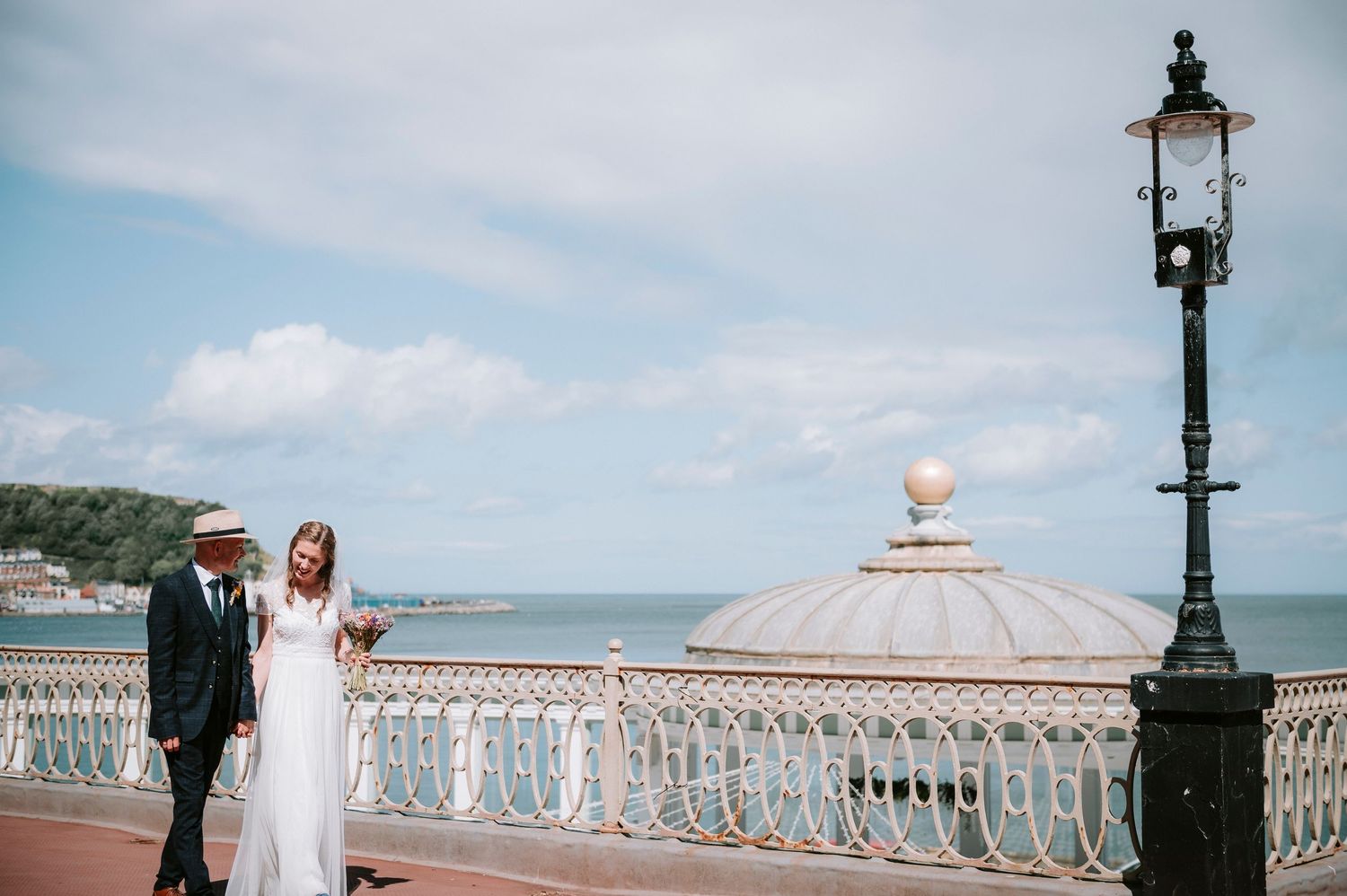 Oceanfront wedding venue with ornate white railings and classic lamp posts.