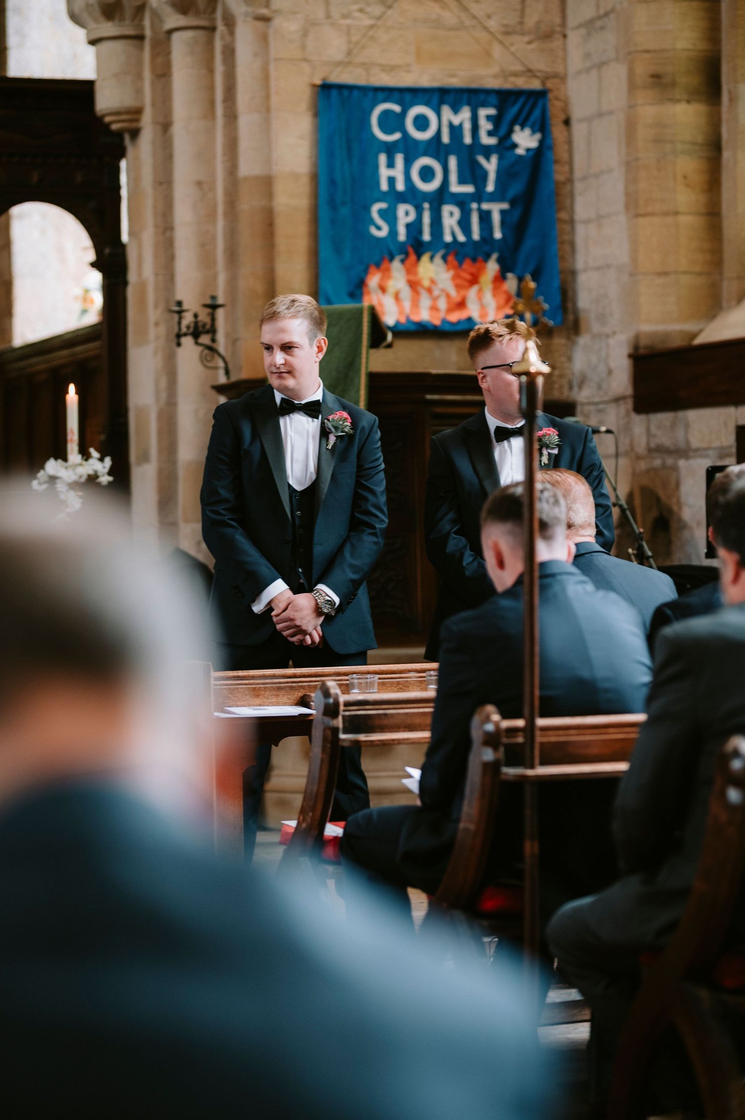 Wedding ceremony inside church with 'Come Holy Spirit' banner displayed behind the altar.