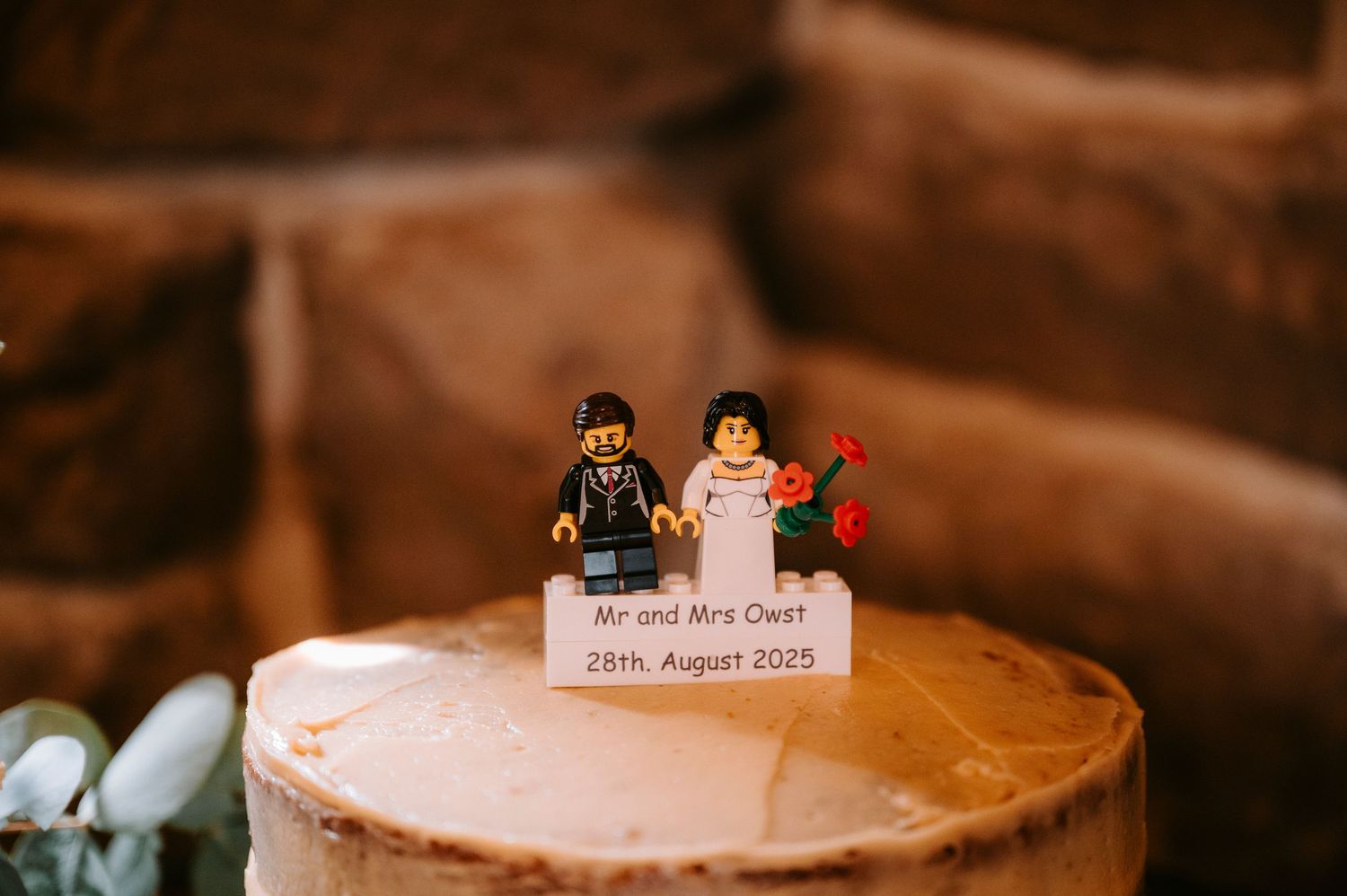 Pink wedding cake topped with custom LEGO bride and groom figurines.