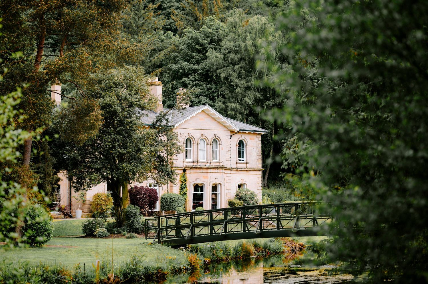 Scenic view of elegant buildings and landscaped gardens with wooden fencing.