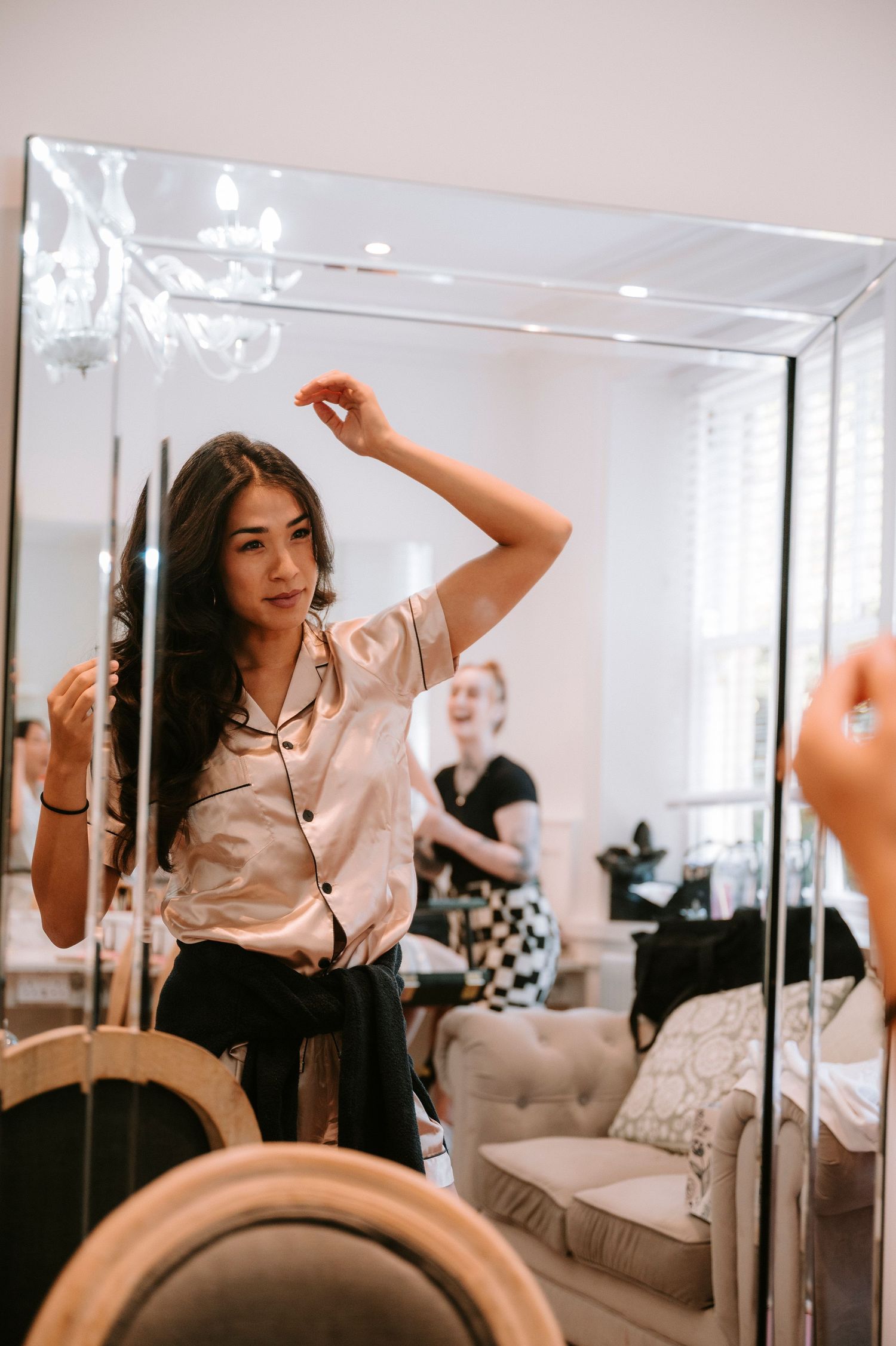 Getting ready scene captured in a mirror reflection during wedding preparations.
