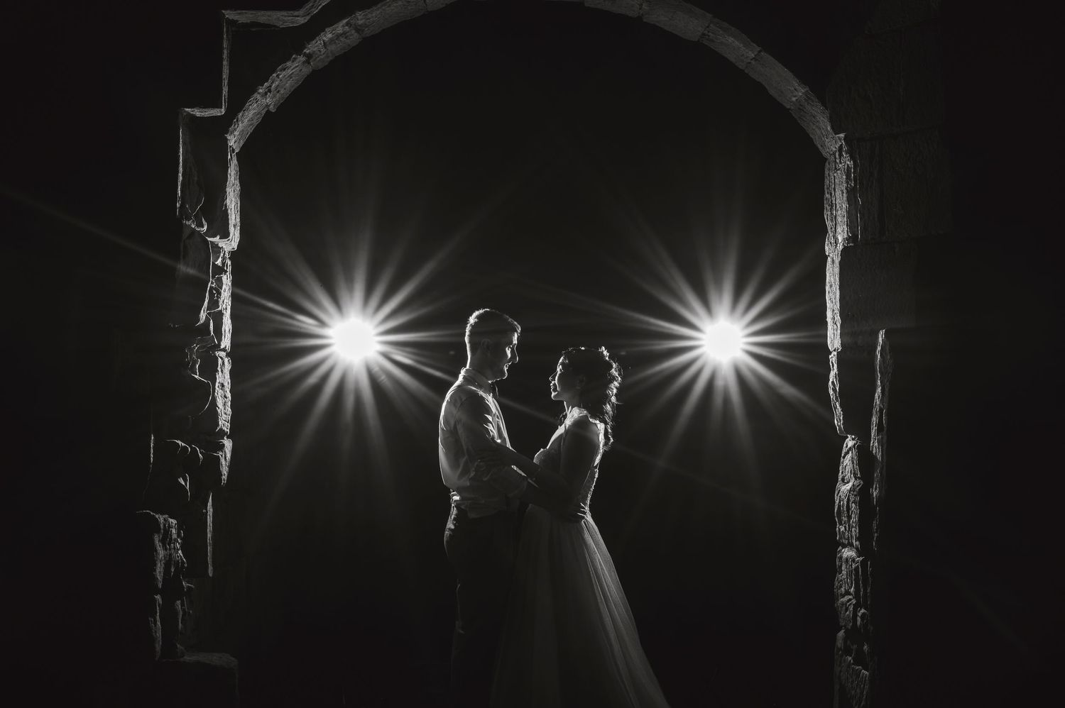 Dramatic black and white photos show silhouettes and light beams creating an artistic sequence of dance movements.