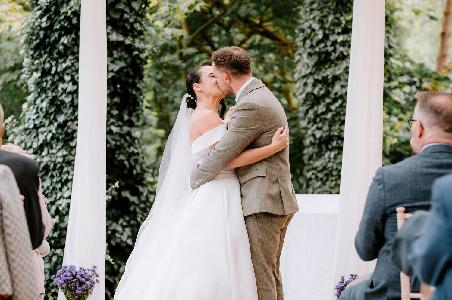 Newlyweds celebrate during outdoor garden wedding ceremony.