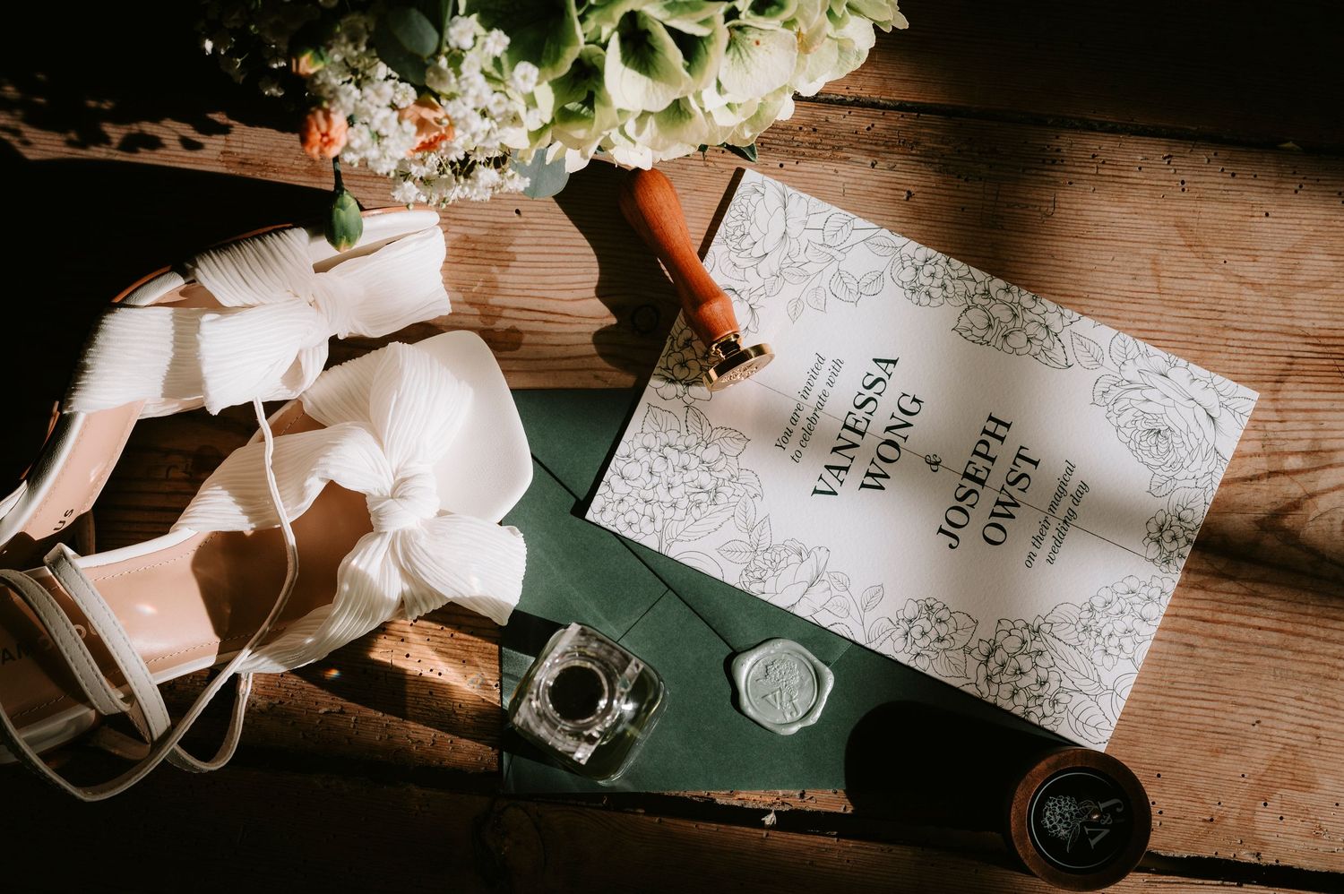 Wedding stationery and decorative elements arranged on a wooden surface with vintage styling.