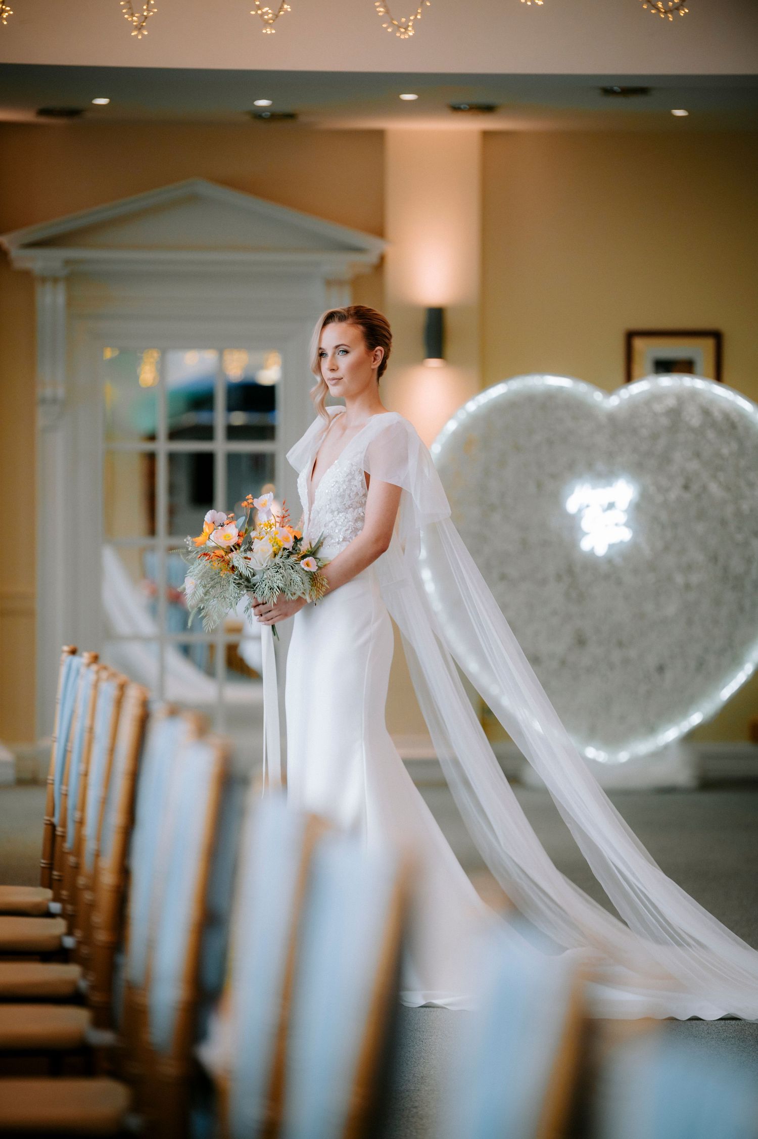 Wedding dress and veil silhouette with romantic lighting and decorative heart backdrop.