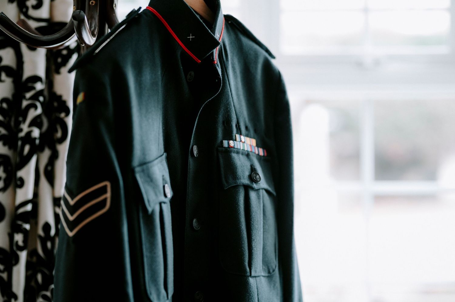 Row of black formal jackets hanging on display for a wedding party.