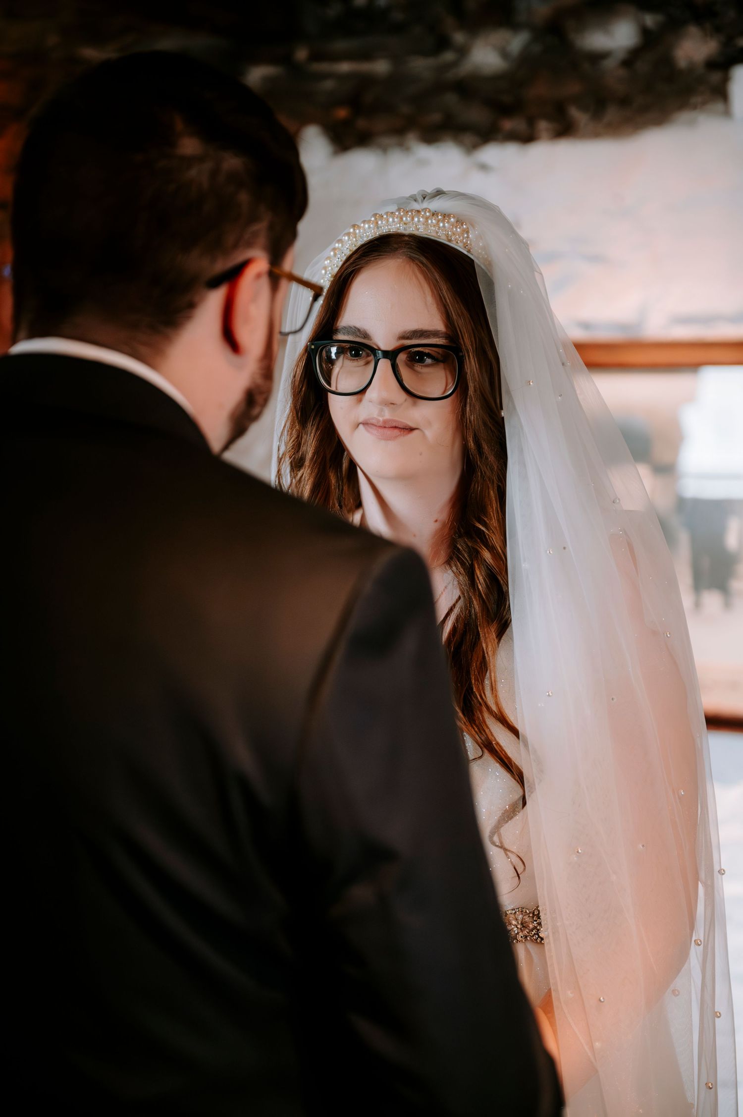 Intimate wedding ceremony moment captured in soft lighting indoors.