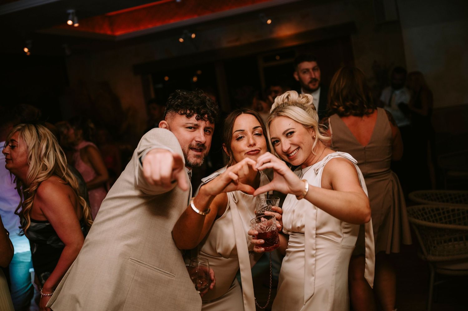Lively dance floor moments captured during evening wedding reception celebrations.