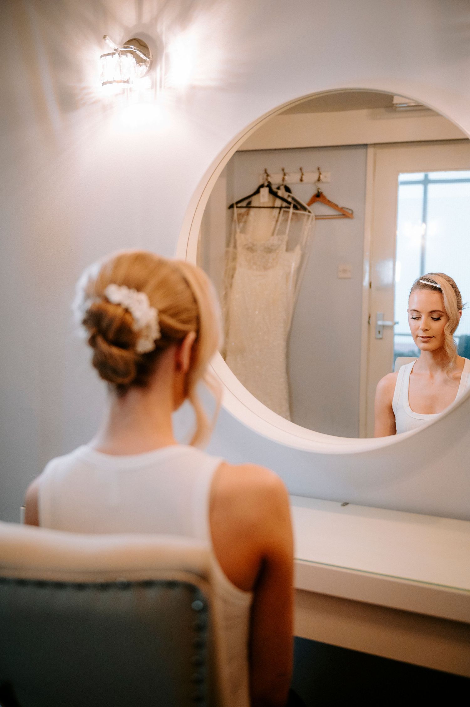 Elegant bridal dressing area with oval mirrors and natural lighting.
