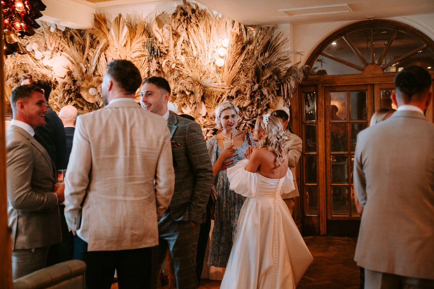Wedding reception venue with warm amber lighting and elegant wooden decor creating a romantic atmosphere.
