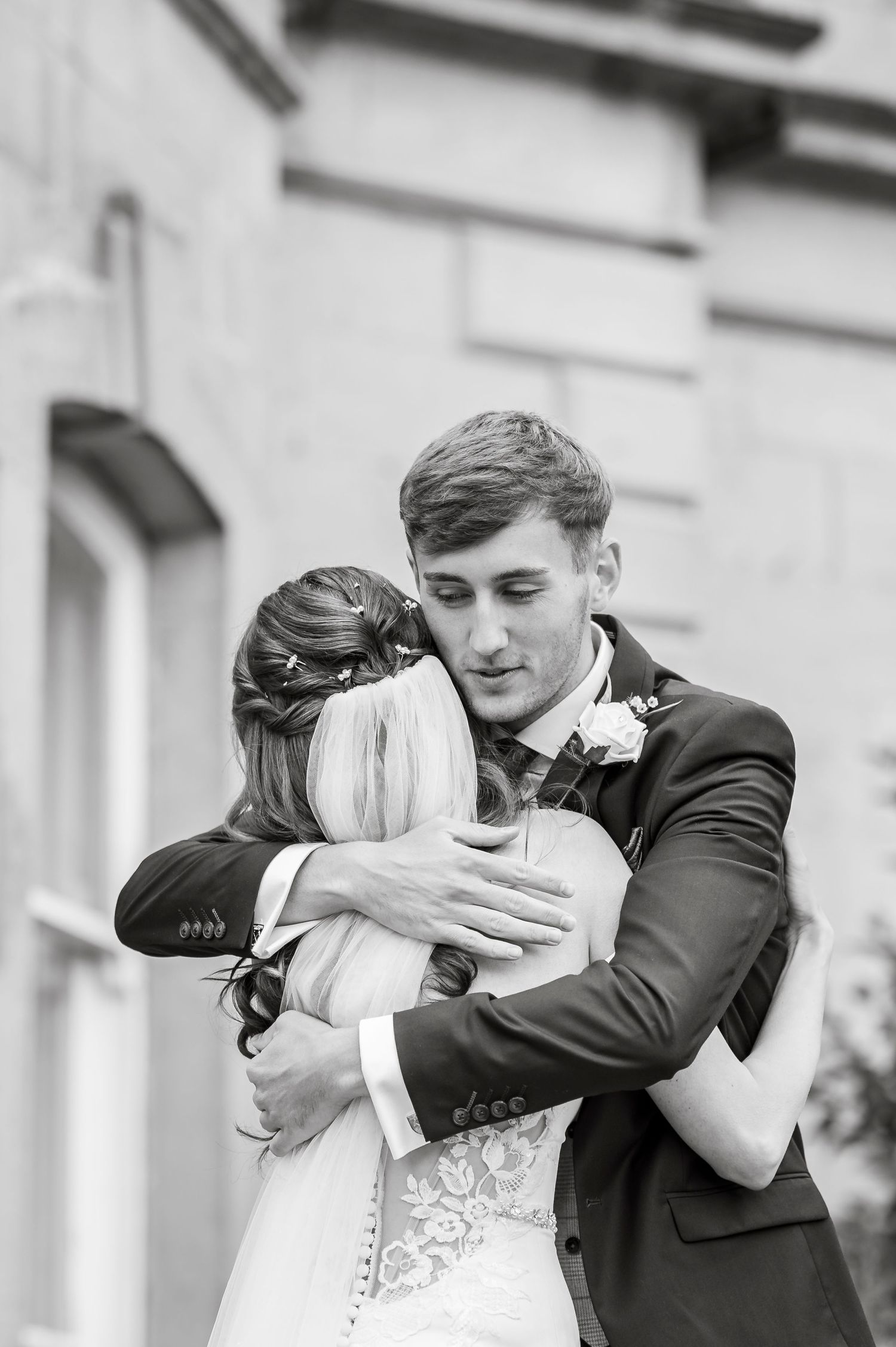 Series of black and white photos showing an emotional first look between newlyweds.
