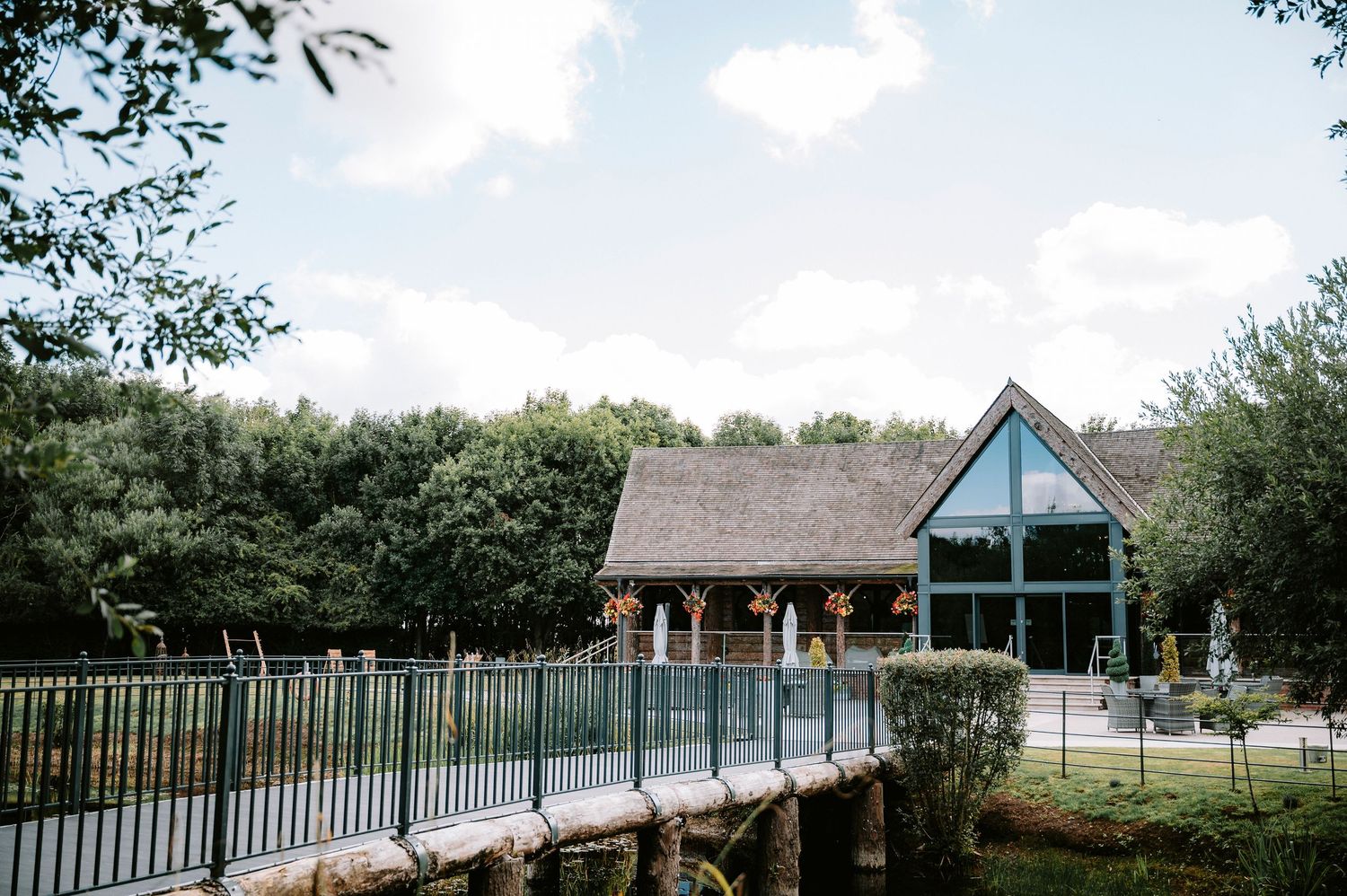 Rustic wooden wedding venue buildings with blue trim set against a scenic outdoor landscape.