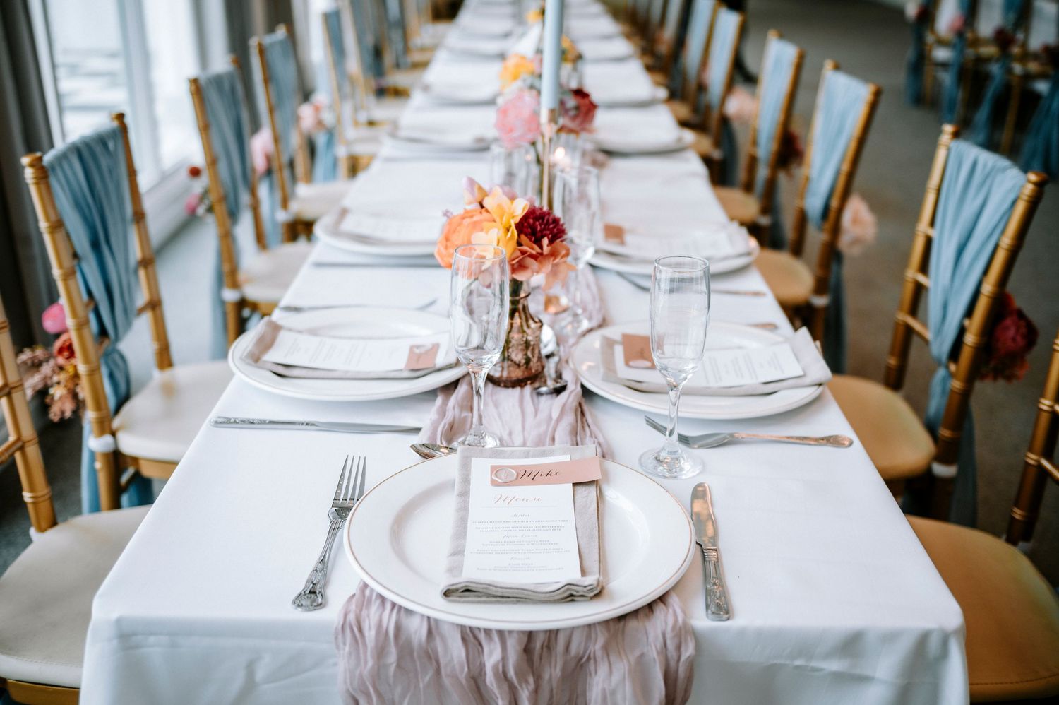 Elegant table settings with white linens and delicate floral centerpieces in a spacious dining room.