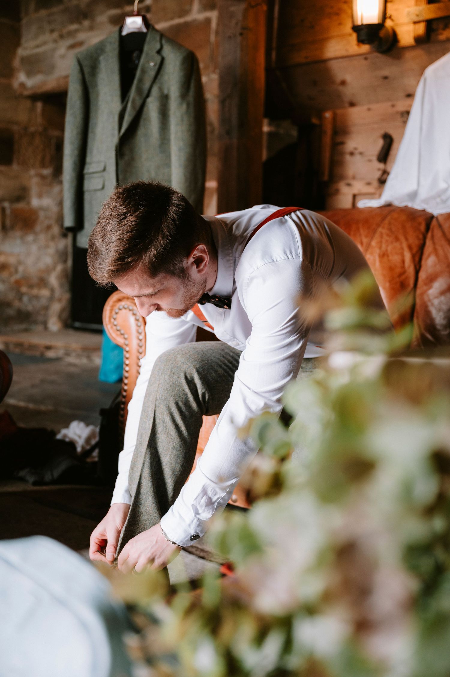 Wedding preparation details in a rustic stone venue with warm lighting.