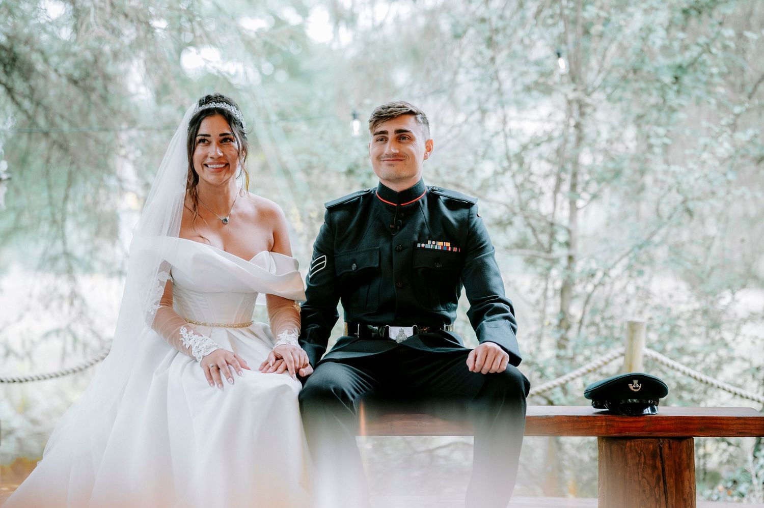 Wedding ceremony taking place on a wooden deck surrounded by pine trees.
