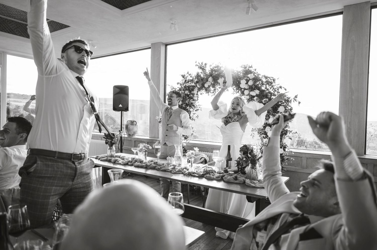 Wedding reception venue with covered porch area and guests celebrating.