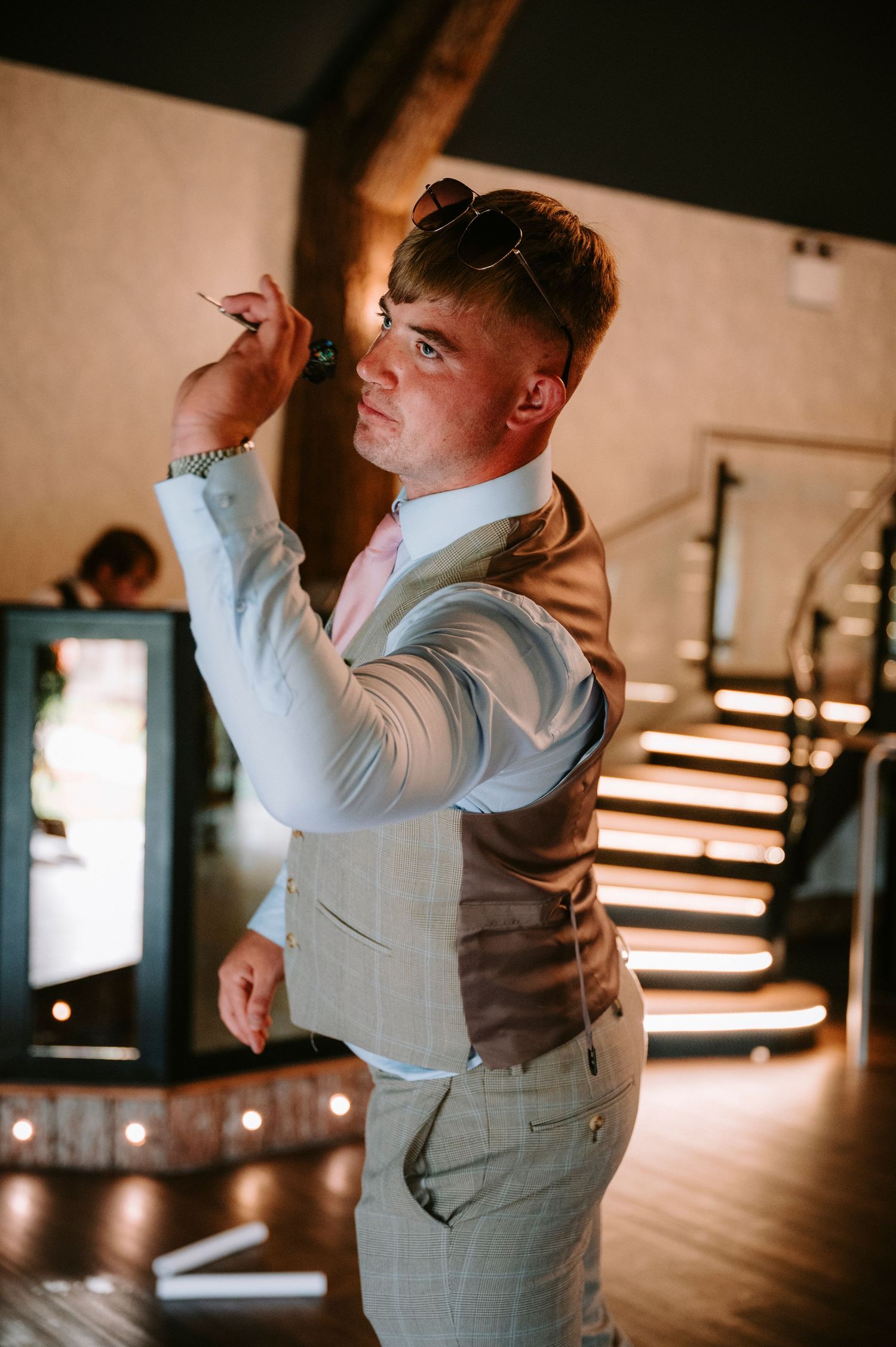 Guest in formal attire strikes a dance pose in atmospheric venue lighting.