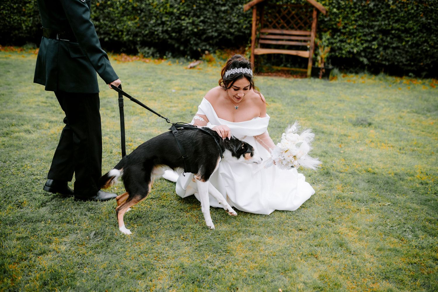 Wedding photography session in a garden with a wooden bench and lush greenery.