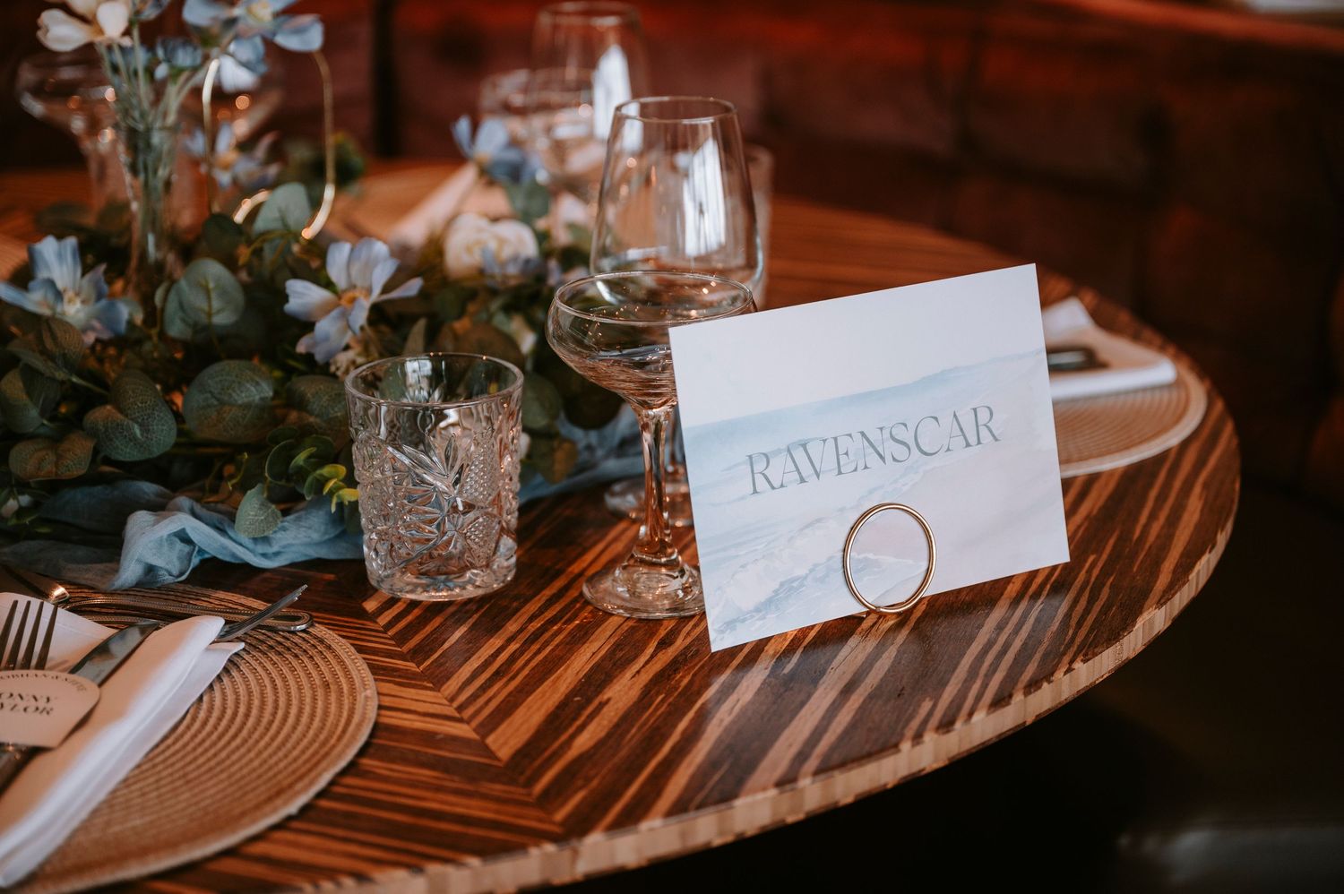 Elegant table setting with place cards and floral arrangements at a wedding reception.
