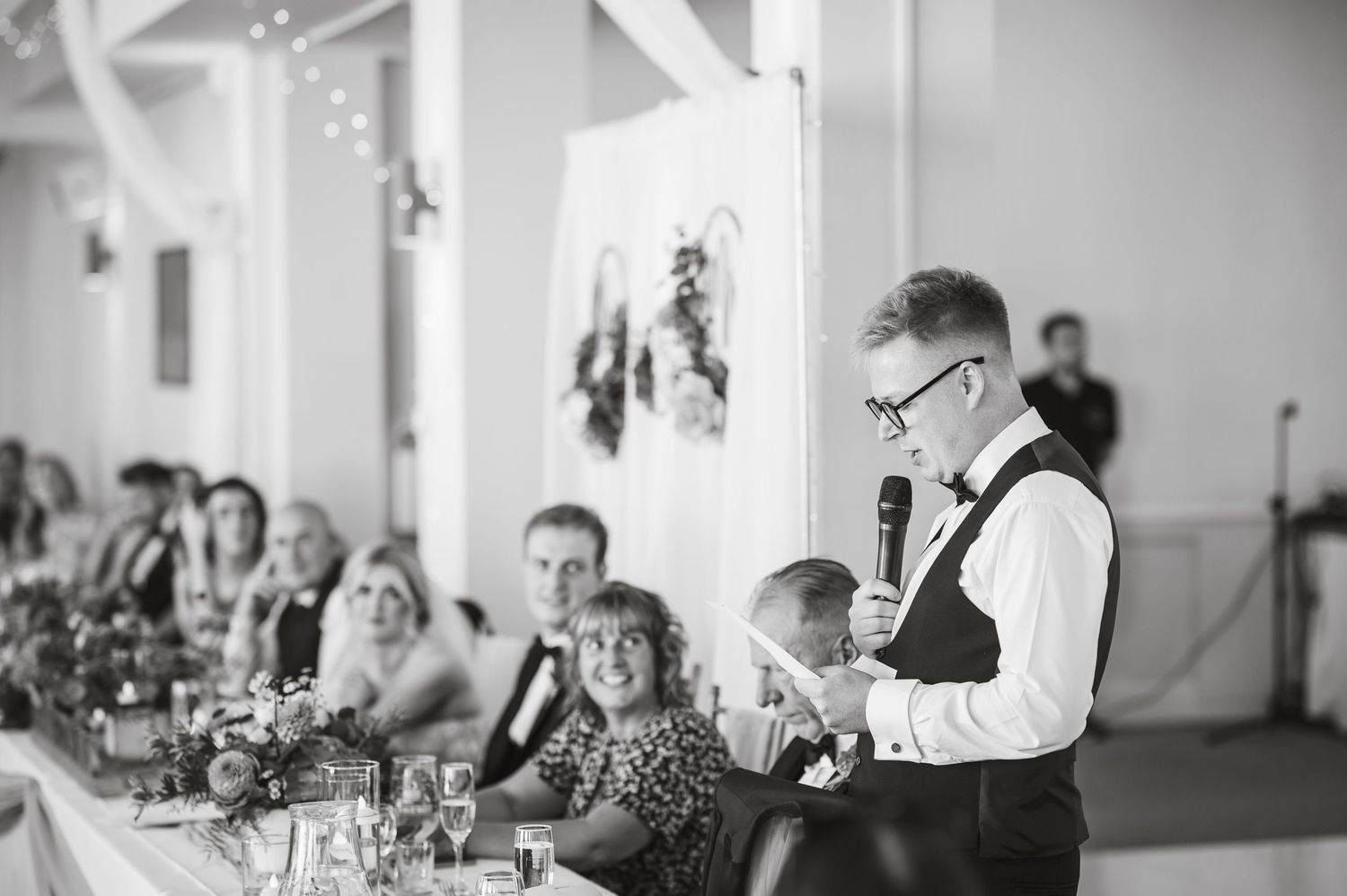 Elegant wedding reception table settings with white linens and floral centerpieces.