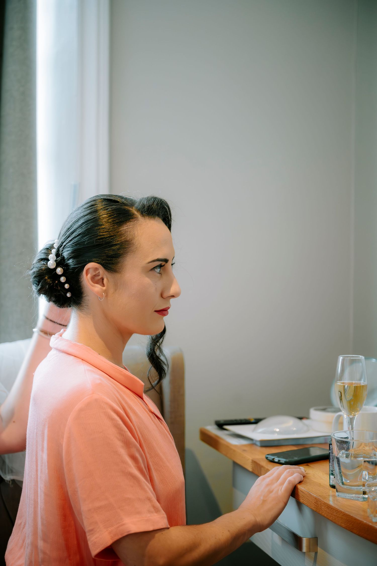 Wedding day preparation scene in a bright room with natural lighting.