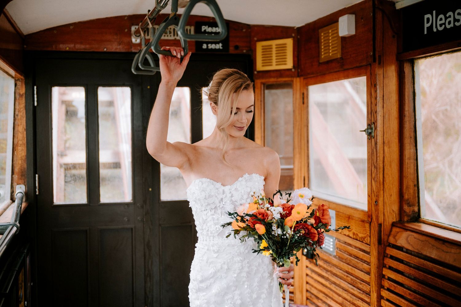 A vintage wooden train car interior serves as a unique wedding photo setting.