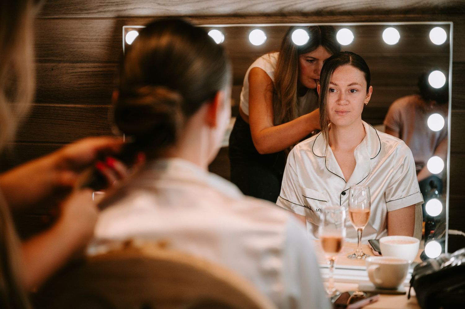 Vanity mirror lights illuminate a dressing room setting with warm ambient glow.
