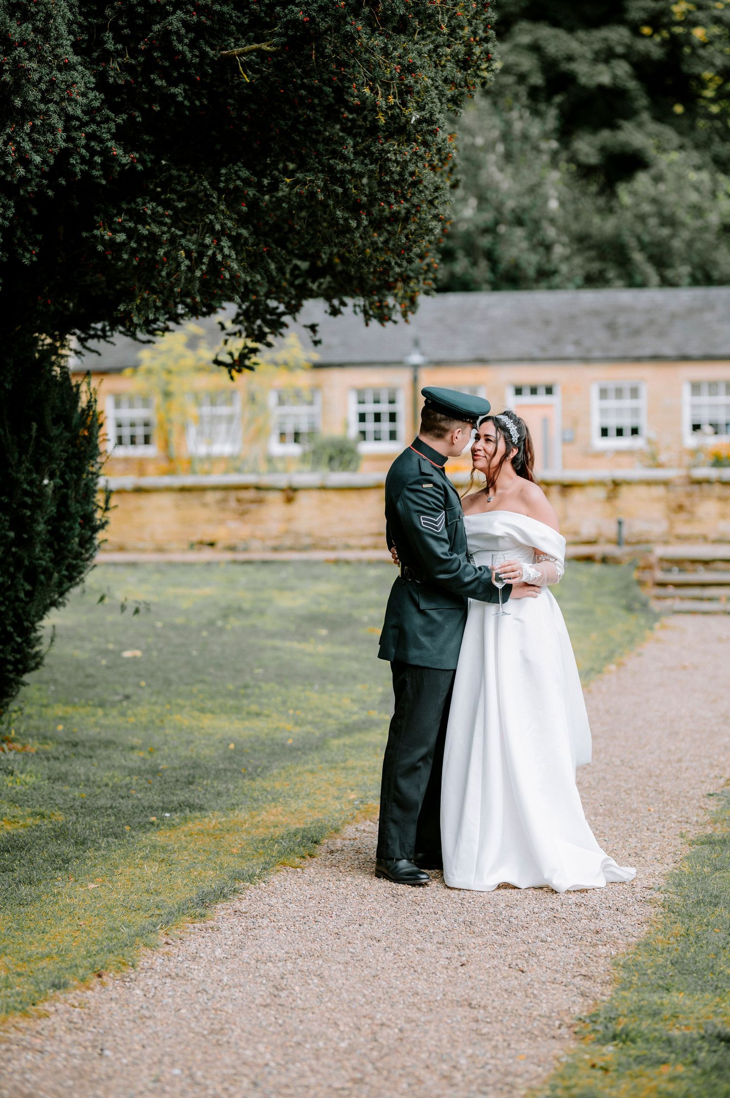 Couple sharing an intimate moment on a garden path during their wedding day.