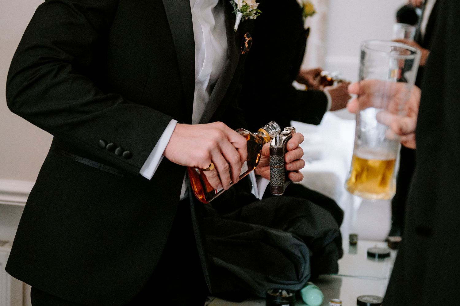 Wedding party members relax with drinks during casual pre-ceremony moments.