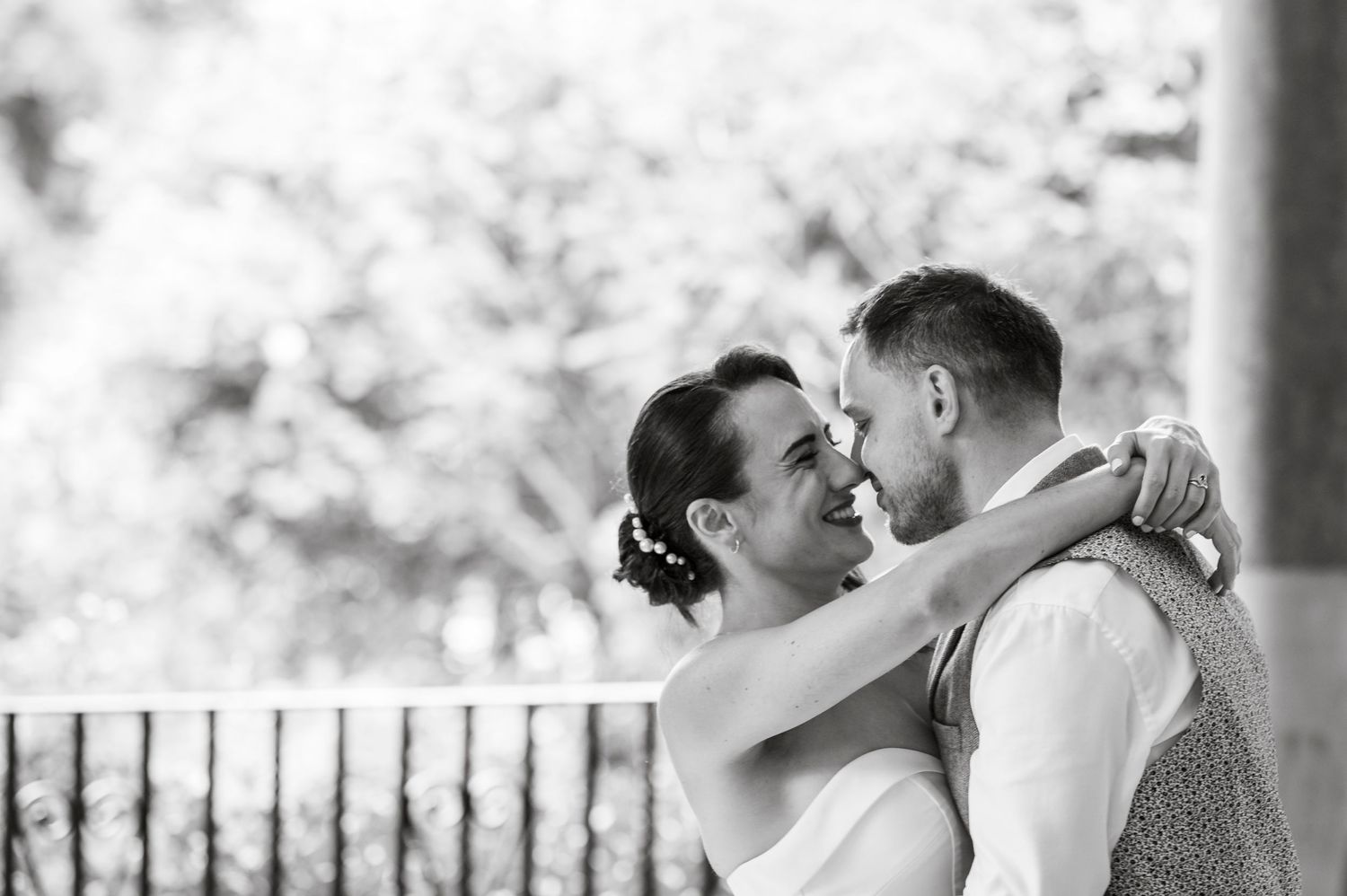 Black and white candid moments of wedding party celebrations on veranda.