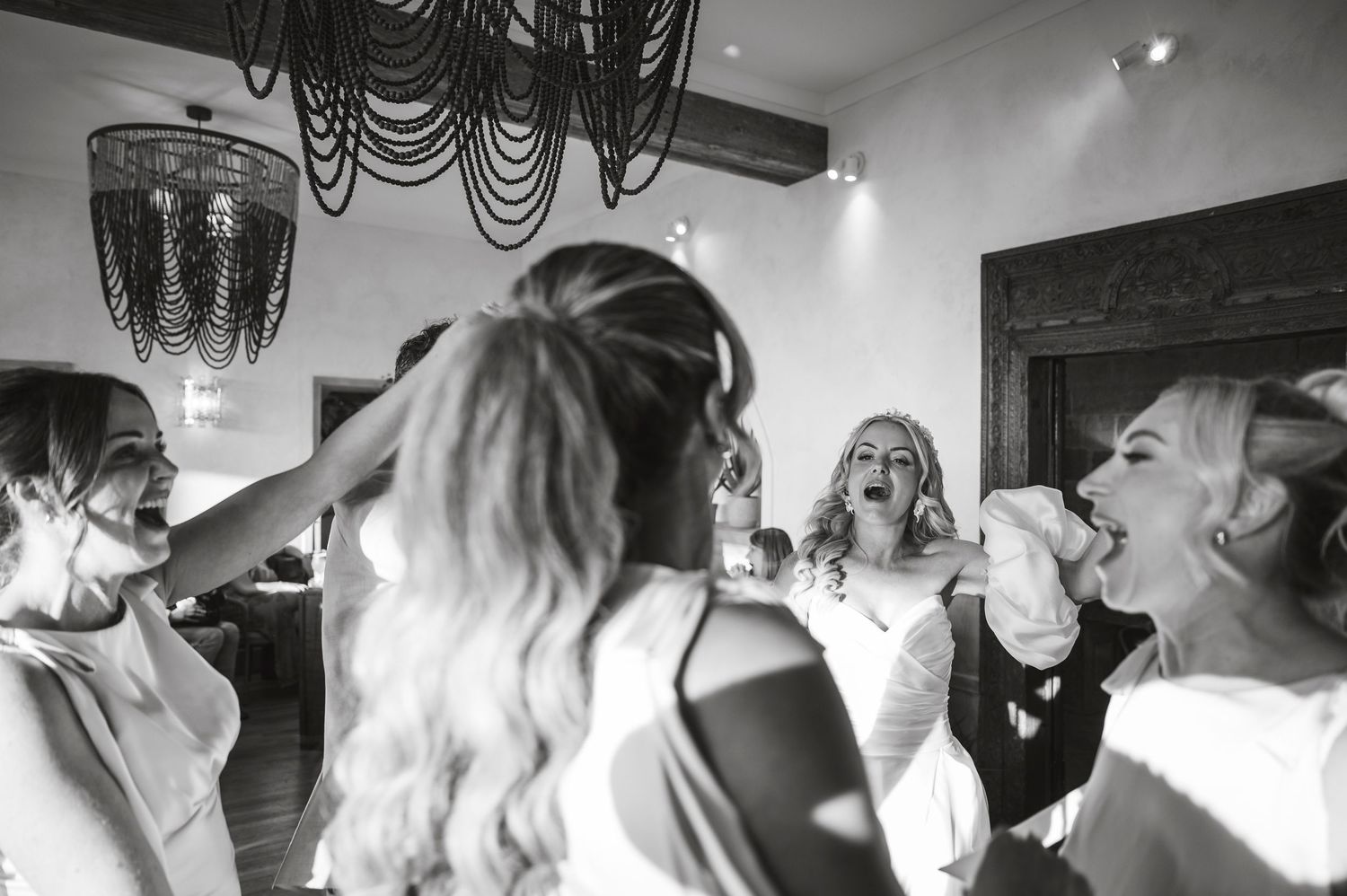 Black and white photos capture candid moments of celebration at an indoor wedding reception.