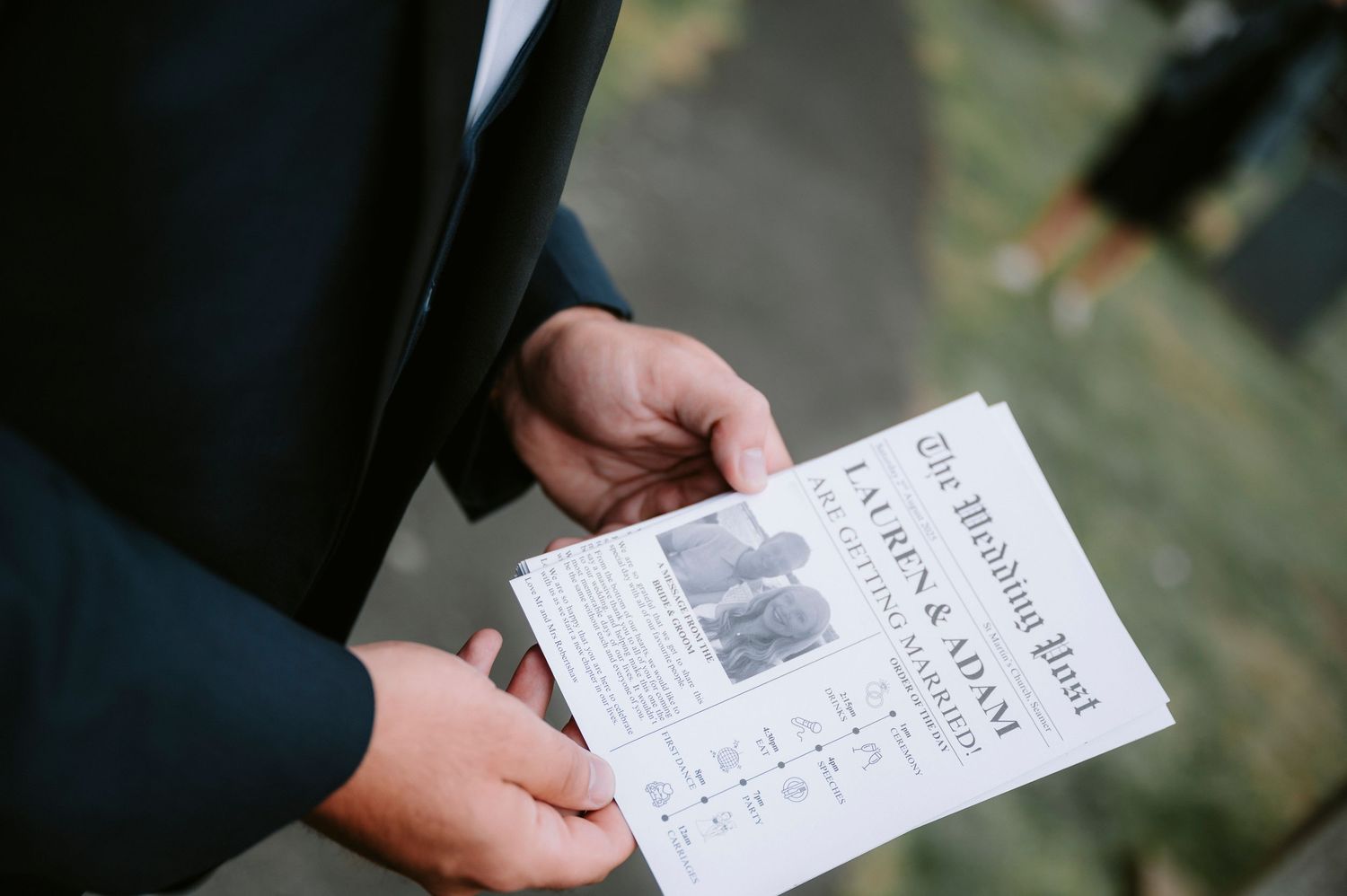 Close-up shot of hands holding a wedding ceremony program or order of service.