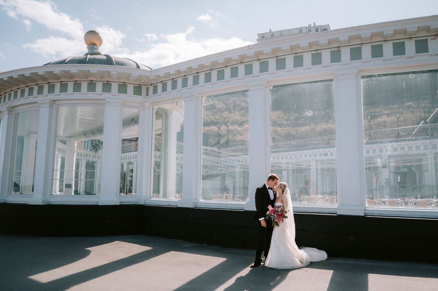 Wedding venue with elegant white architecture and domed ceiling overlooking the ocean.