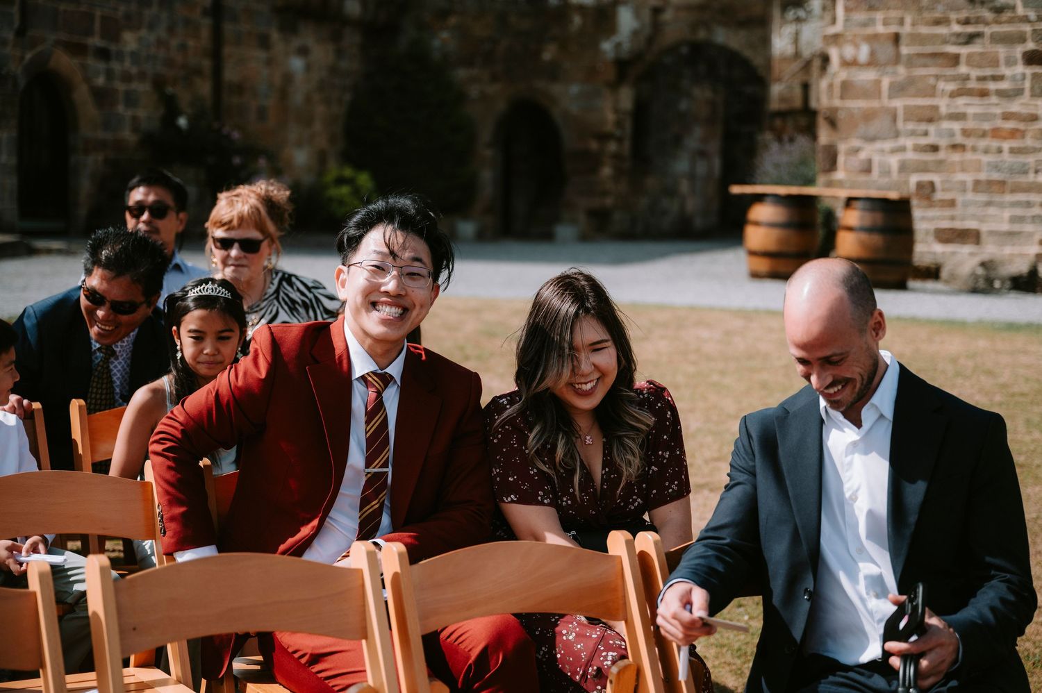Wedding guests seated at reception tables in a rustic brick venue.