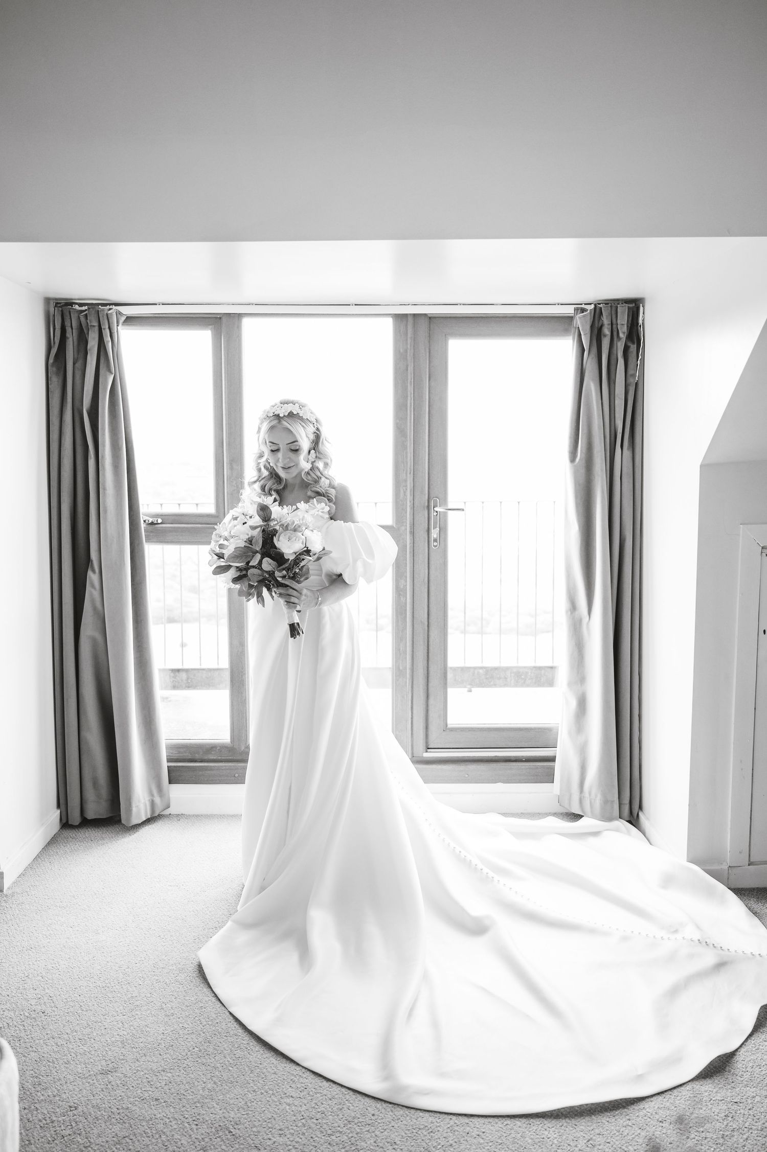 Minimalist wedding dress detail shot in a bright room with natural window light.