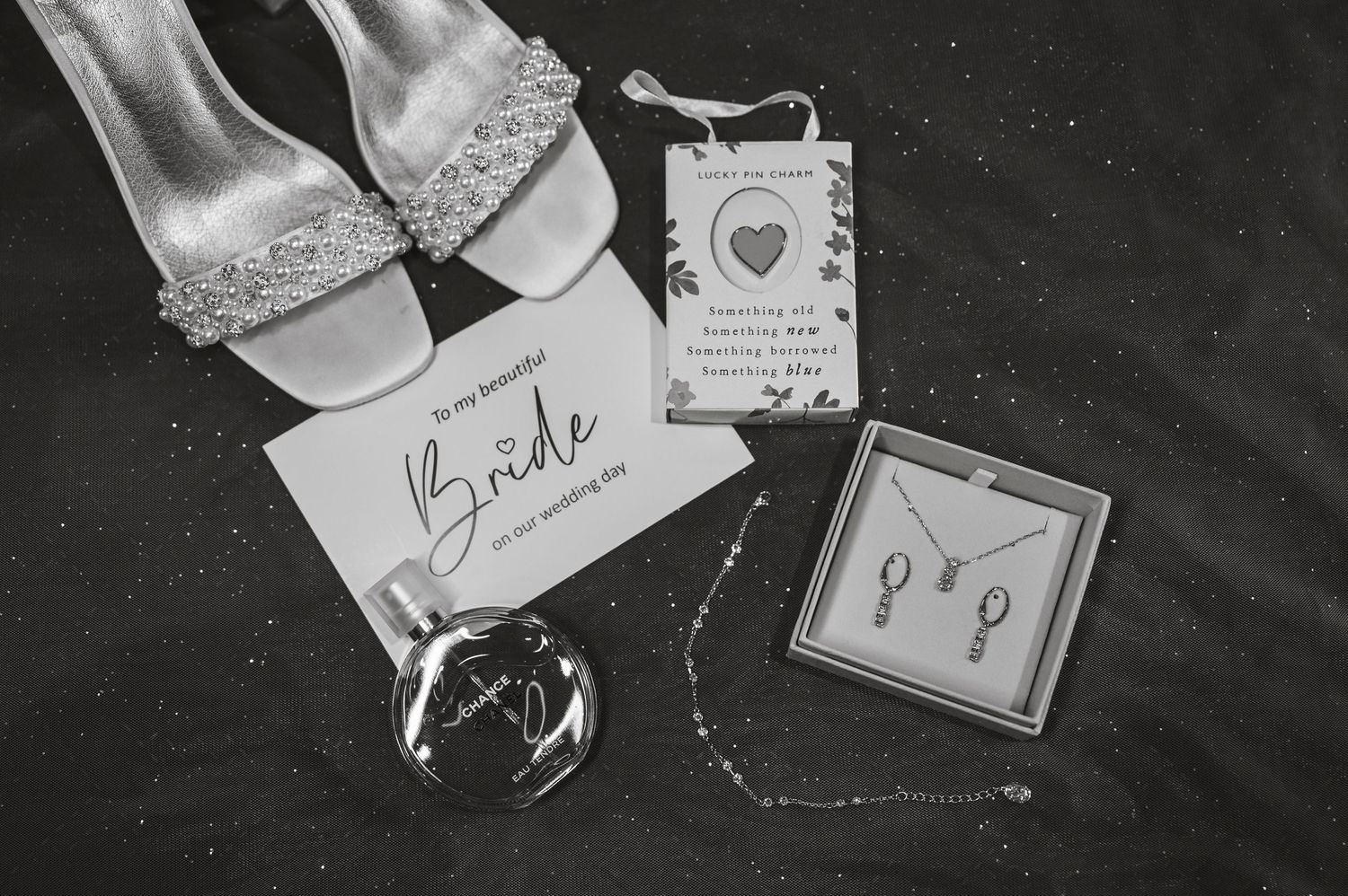 Wedding invitation suite and accessories arranged in black and white.