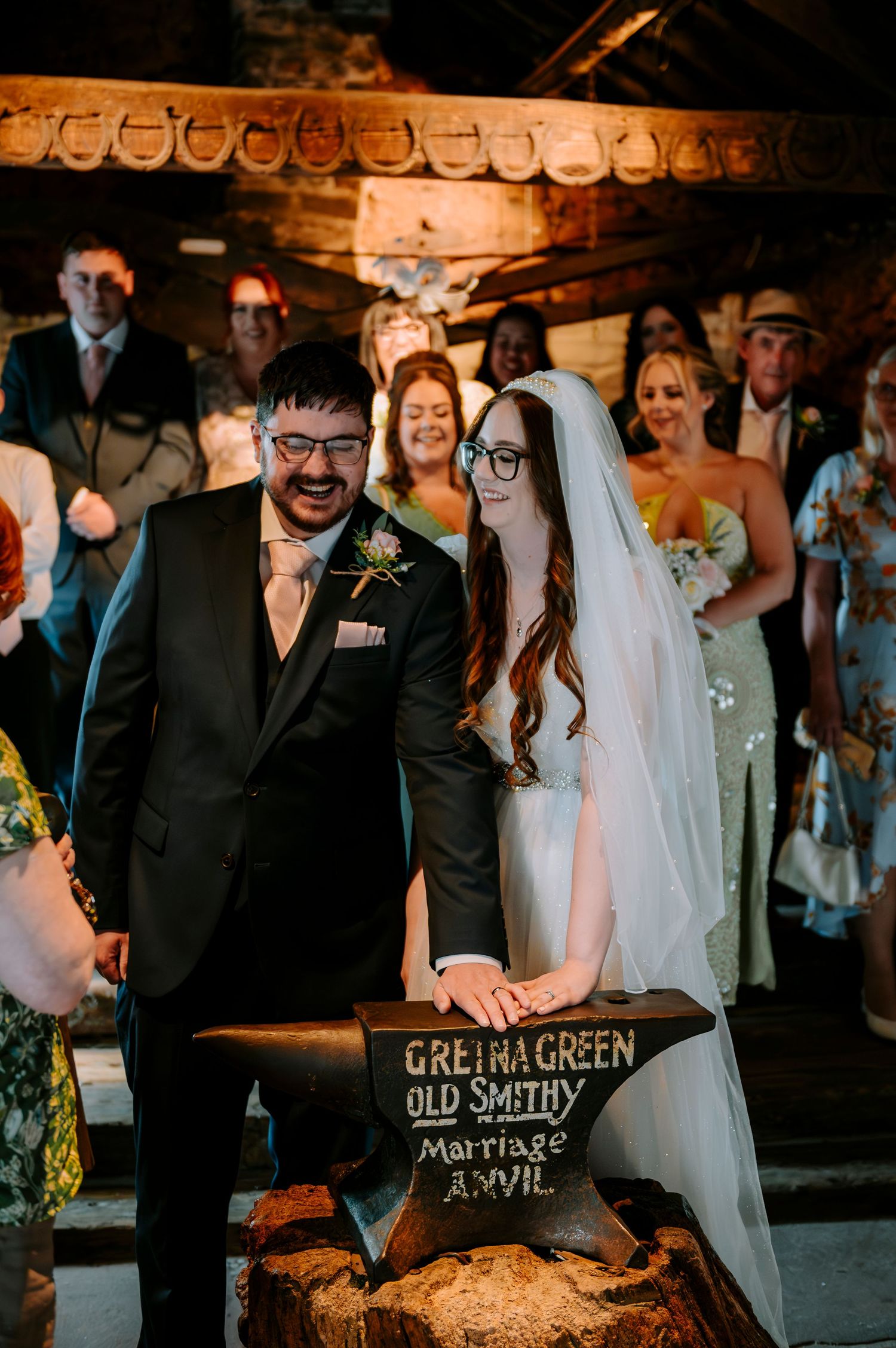 A wedding ceremony at Gretna Green Old Smithy with guests gathered around an anvil.