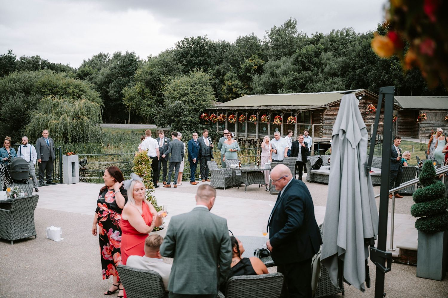 Outdoor wedding reception setup with umbrellas and guests enjoying a casual atmosphere.