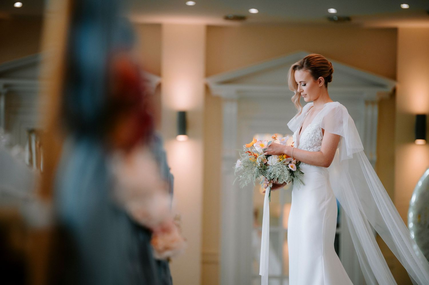 Wedding ceremony preparations in an elegant indoor venue with soft lighting.